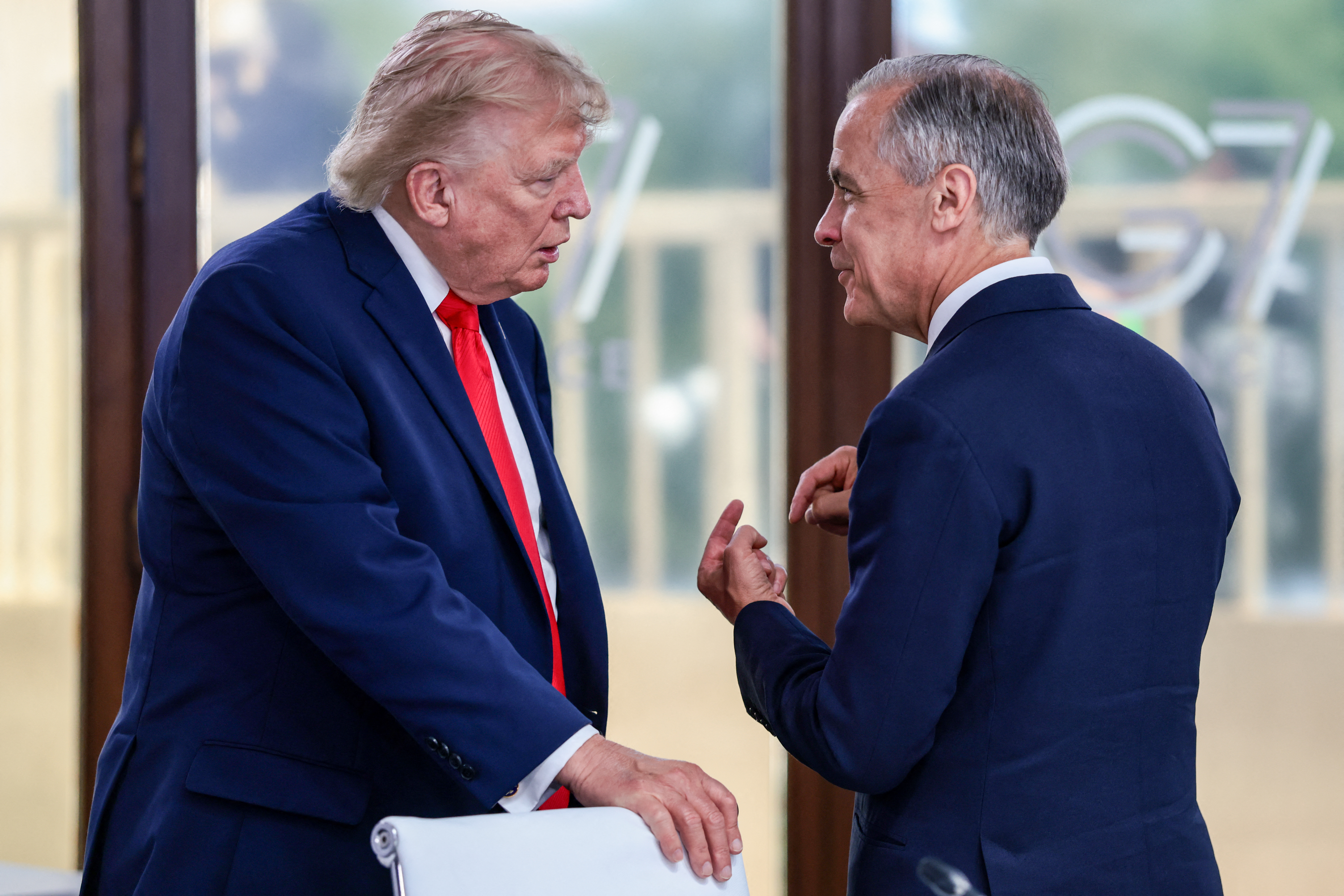US President Donald Trump speaks with Canada's Prime Minister Mark Carney during a work lunch as part of the G7 summit, in Evian, eastern France, on June 16, 2026.