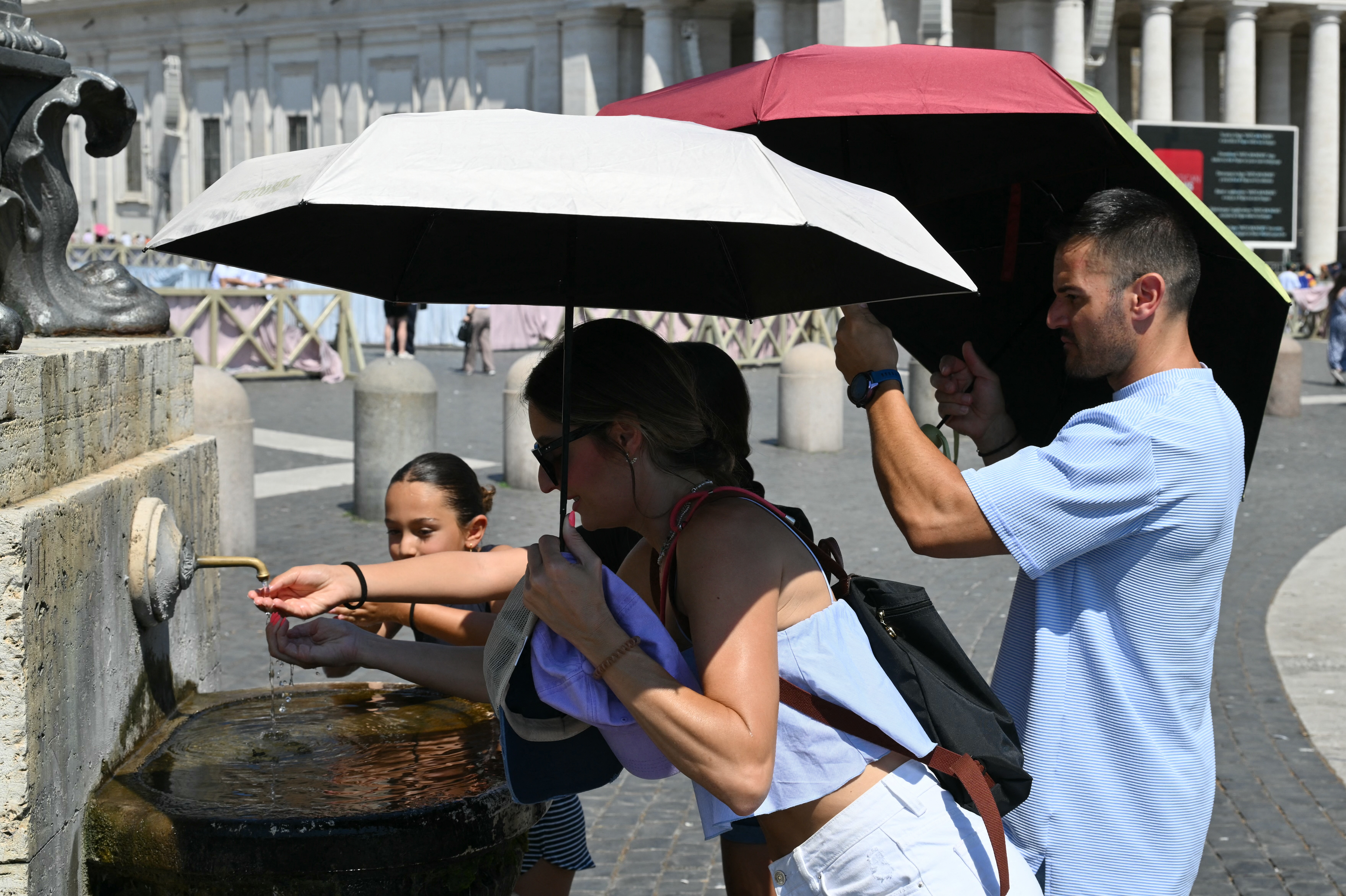People cool off in a fountain as they wait for the Sunday Angelus prayer led by Pope Leo XIV in St. Peter's square at the Vatican on June 28, 2026. (Photo by Alberto PIZZOLI / AFP)