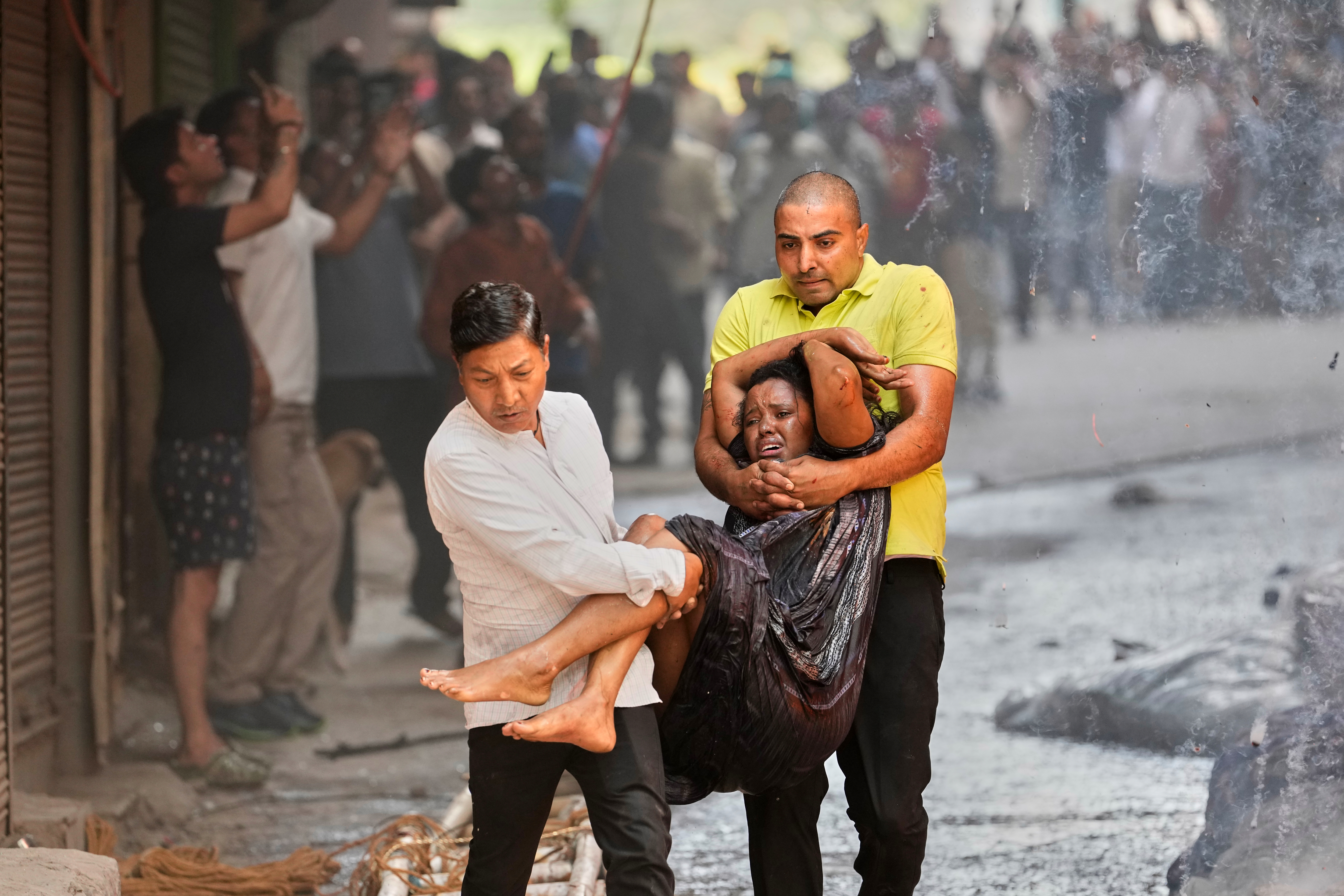 Local people rescue a foreign national from a hotel fire in New Delhi, India, Wednesday, June 3, 2026. (AP Photo/Manish Swarup)