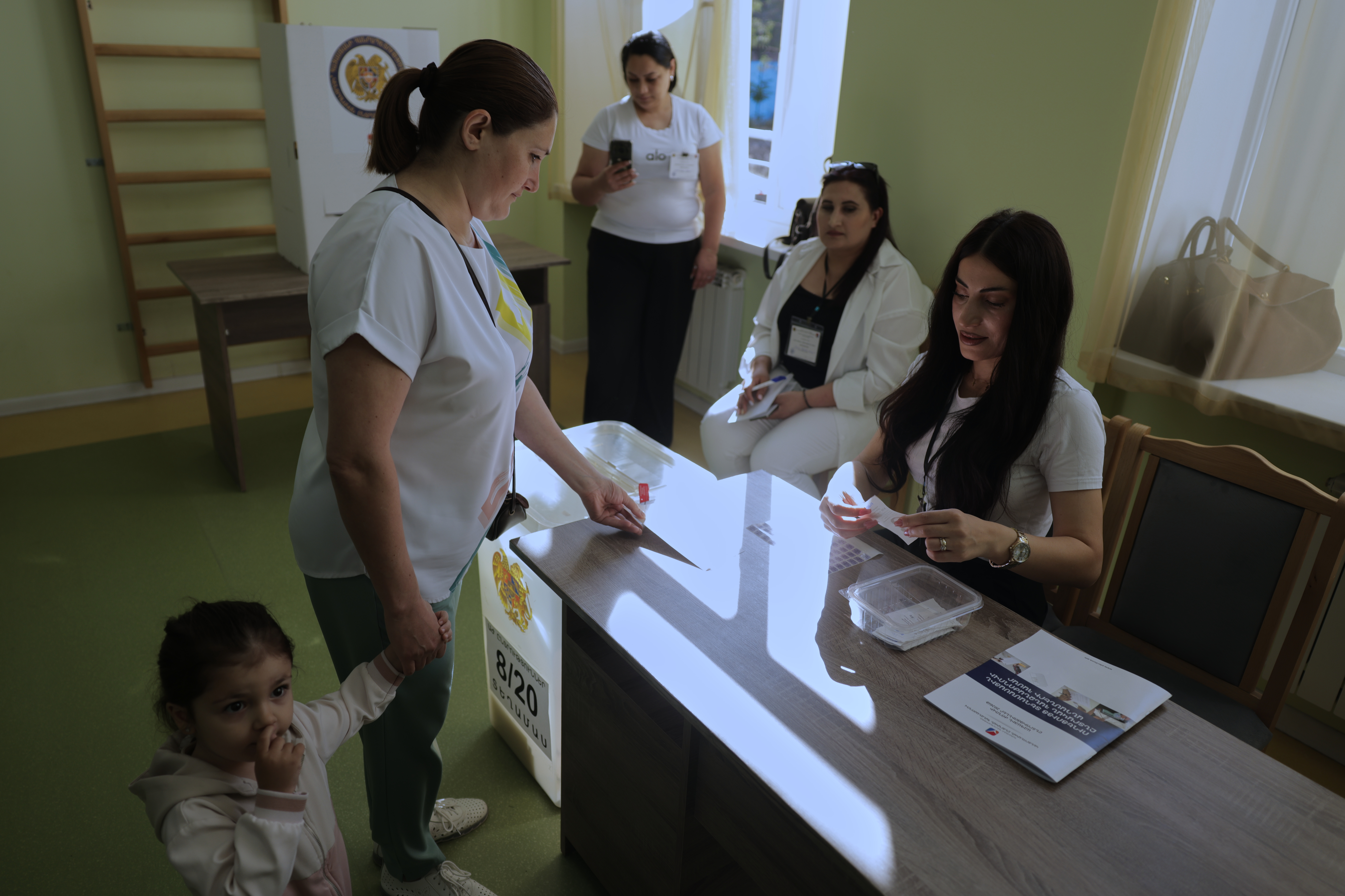 A woman gets a ballot at a polling station.