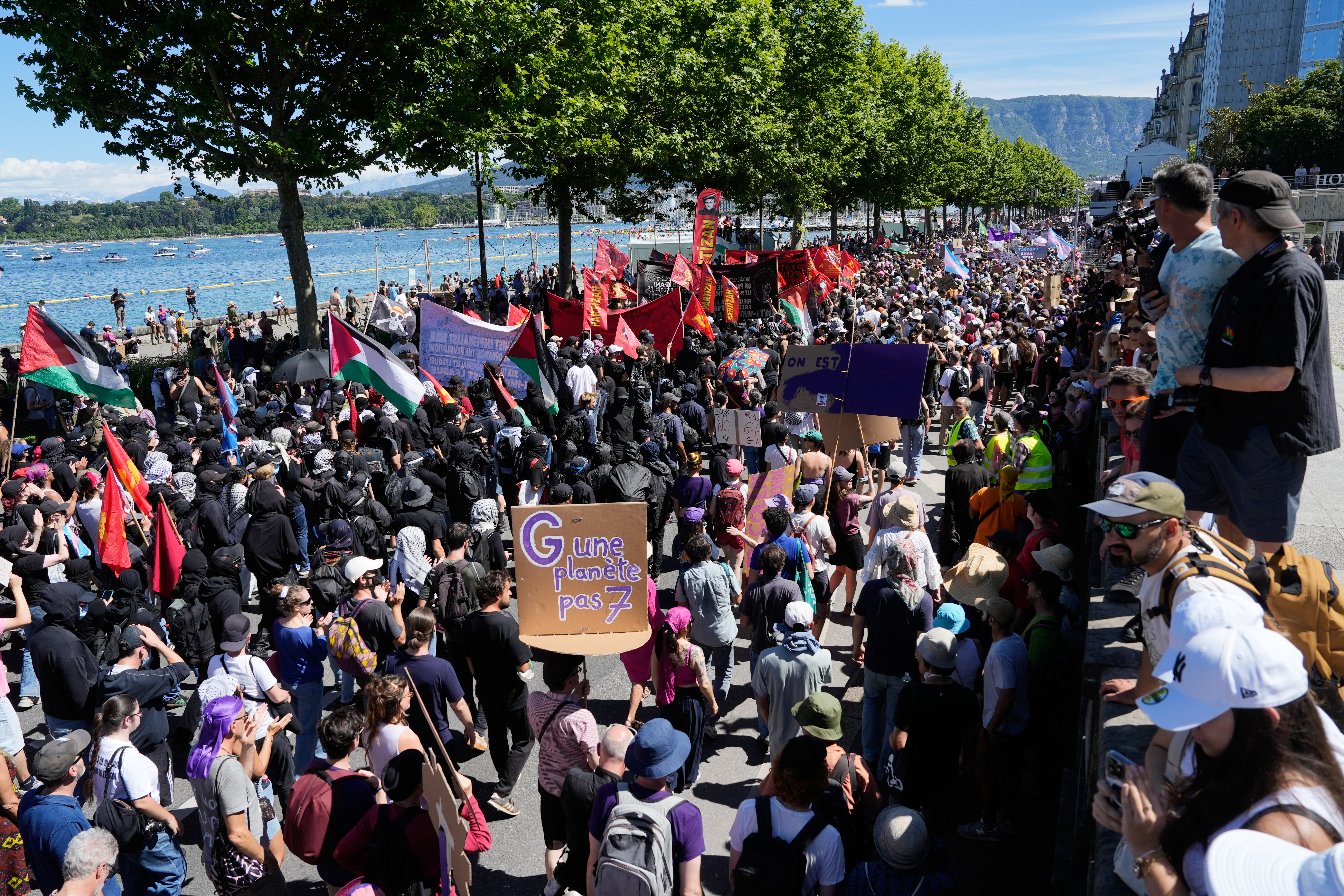 A protester holds a sign which reads "There is one planet, not 7" as they participate in a "No G7" demonstration in Geneva, Switzerland, Sunday, June 14, 2026, ahead of the G7 summit scheduled to take place June 15-17. (AP Photo/Baz Ratner)
