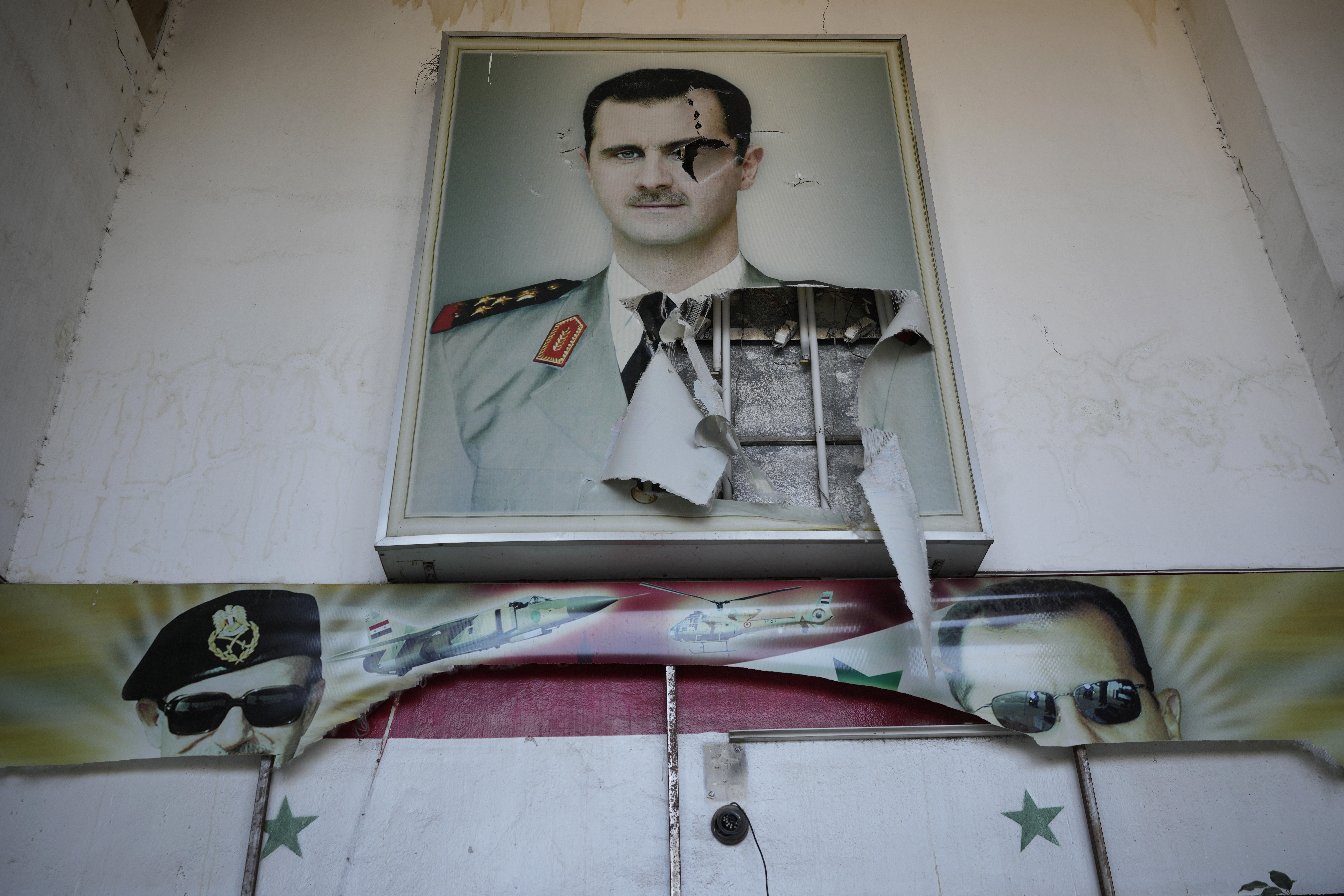 A torn posters shows the late Syrian President Hafez Assad and his son the ousted Syrian president Bashar Assad