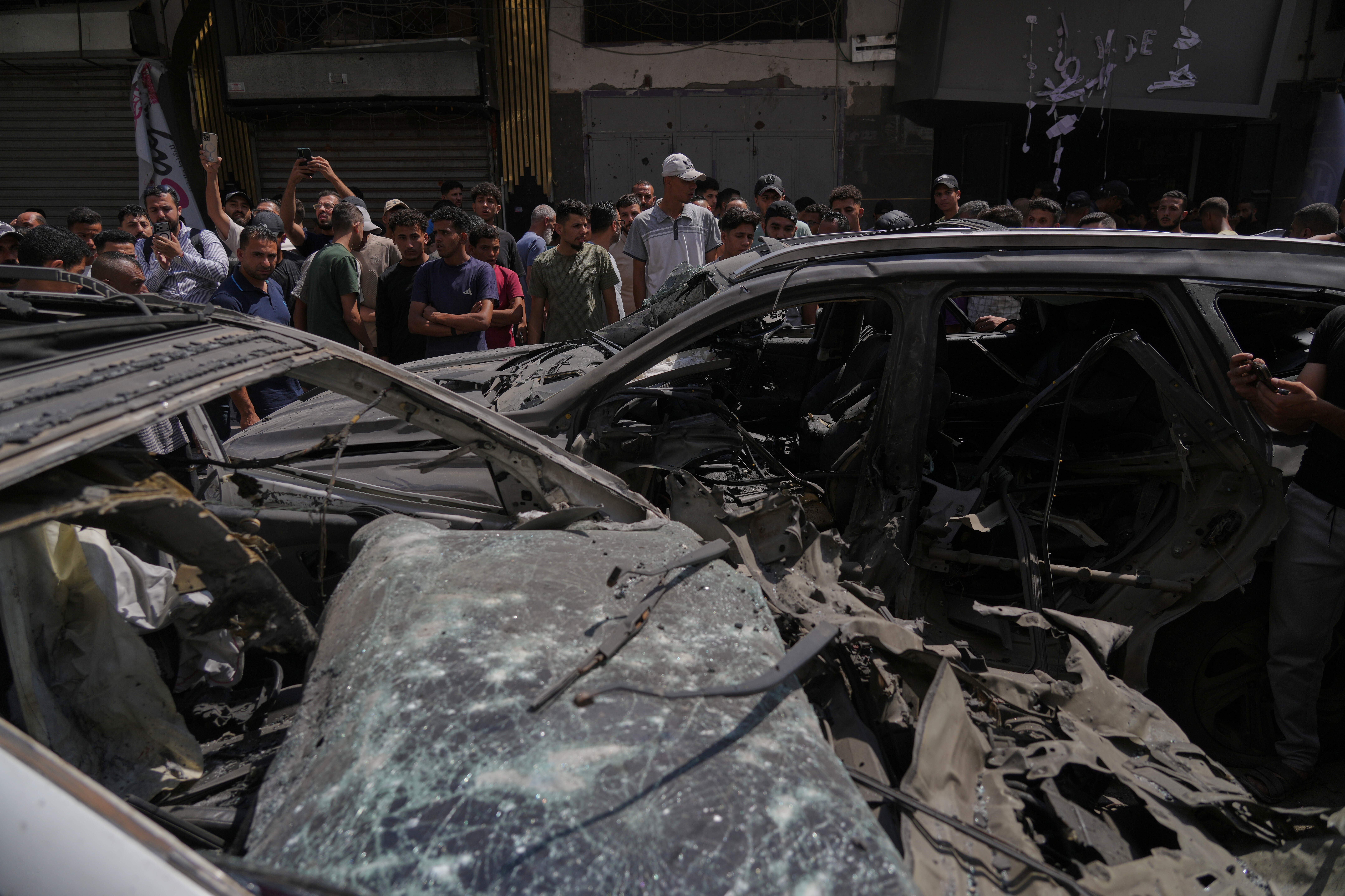 Palestinians inspect damaged vehicles following an Israeli airstrike in Gaza City, Monday June 22, 2026. (AP Photo/Jehad Alshrafi)