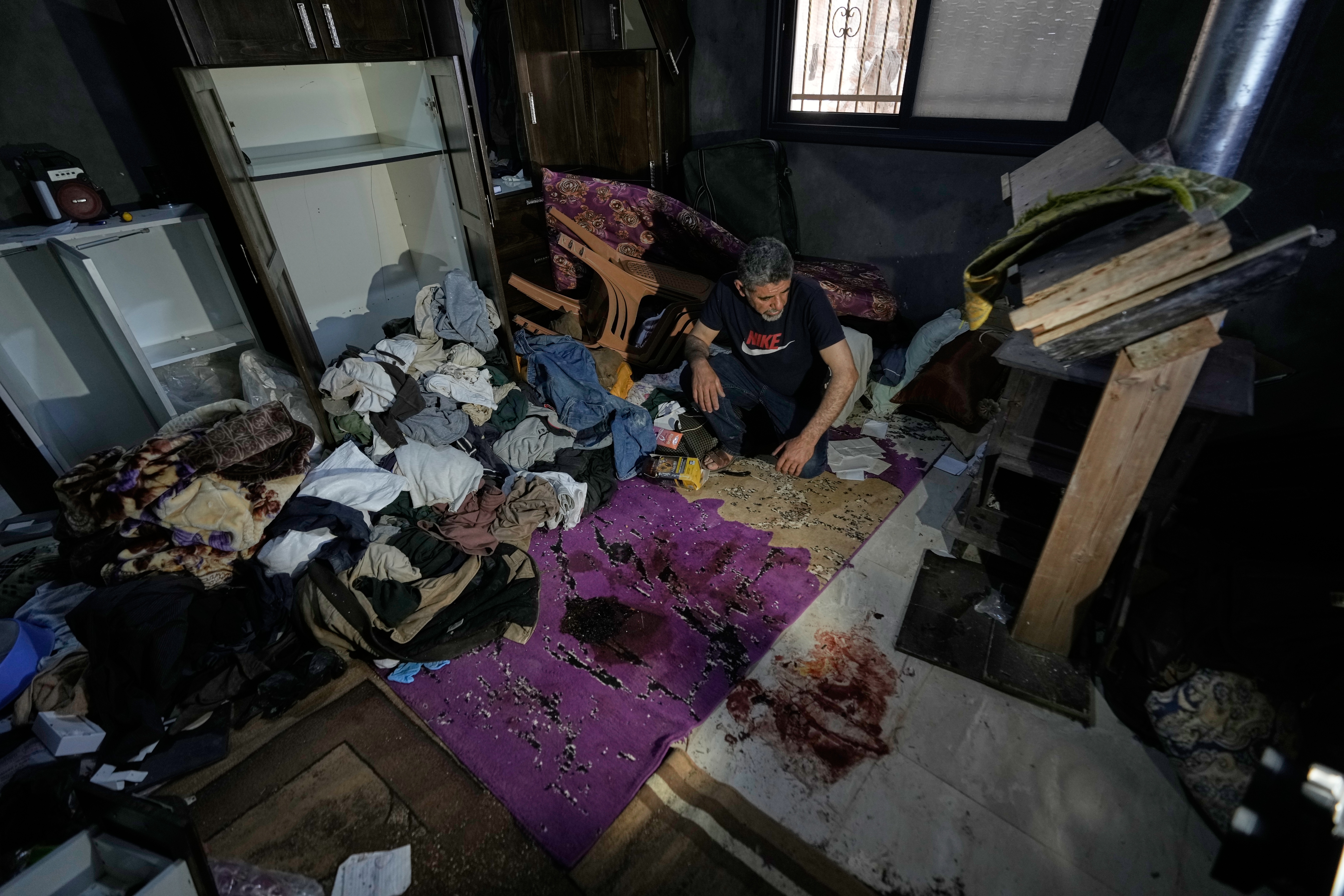 A Palestinian man inspects the bloodstained bedroom of Mustafa al-Khatib, who was killed during an Israeli army raid at his home in the early morning, in the West Bank village of Sarta, west of Salfit, Thursday, June 25, 2026. (AP Photo/Majdi Mohammed)