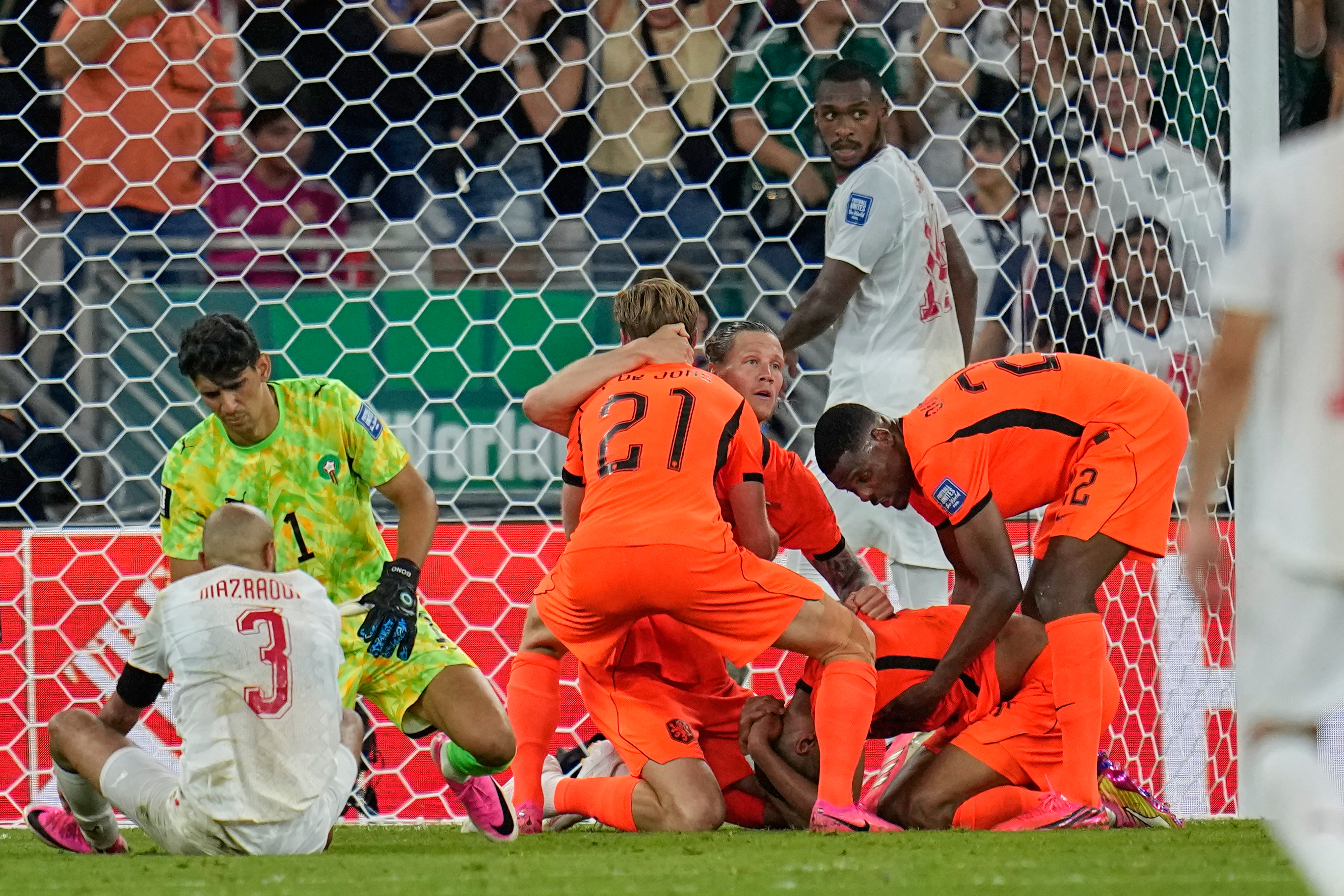 Netherlands' Cody Gakpo, kneeling, is congratulated by teammates after scoring his team's first goal during the World Cup round of 32 soccer match between the Netherlands and Morocco in Guadalupe, near Monterrey, Mexico, Monday, June 29, 2026. (AP Photo/Ricardo Mazalan)