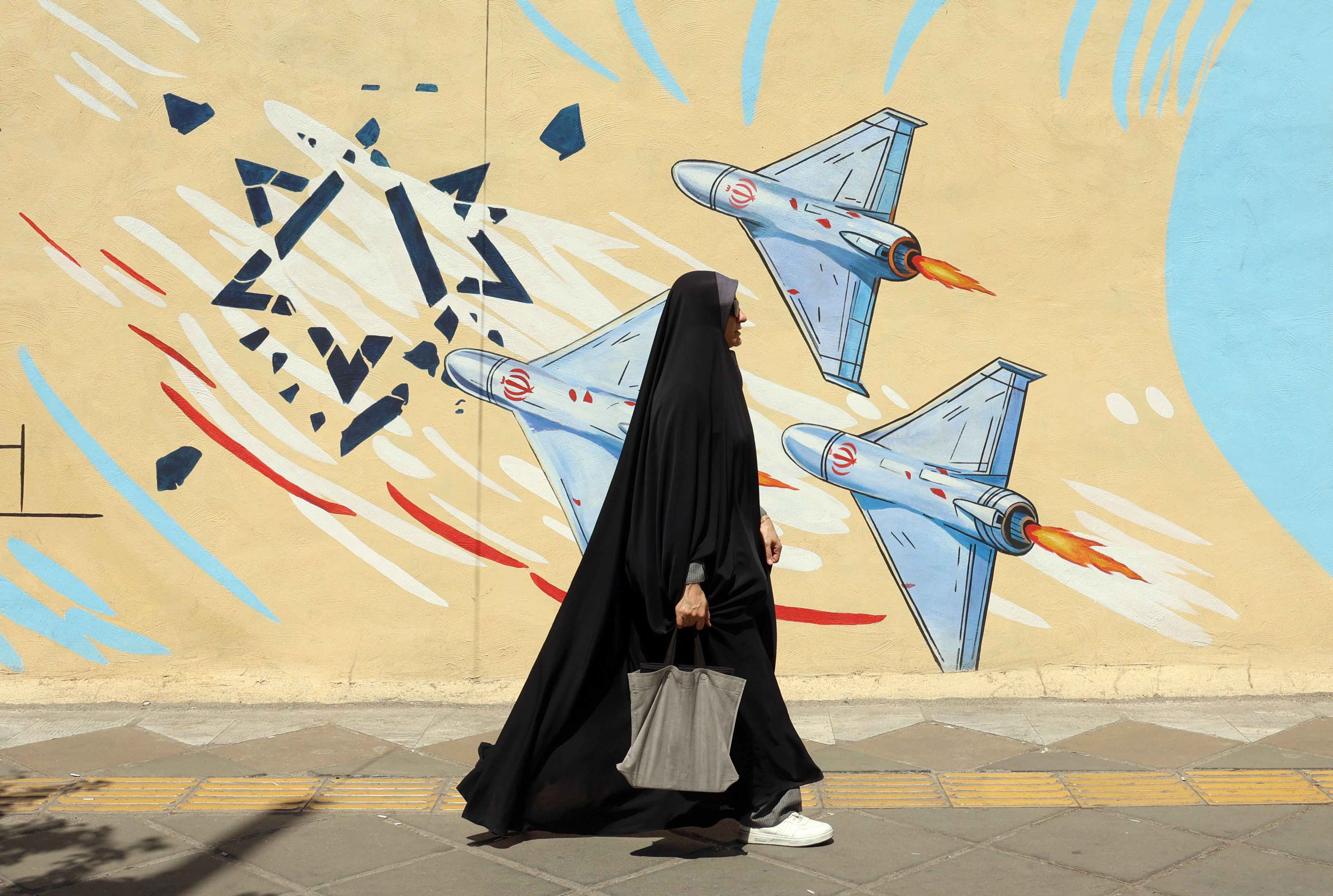 epa13012529 An Iranian woman walks next to an anti-US and Israeli mural in Tehran, Iran, 03 June 2026. Iran and the US traded strikes despite a ceasefire as the conflict involving Iran, the US, and Israel continues. According to US Central Command (CENTCOM), US forces intercepted multiple Iranian ballistic missiles and drones and conducted self-defense strikes on Qeshm Island in response to attempted attacks by Iran across the Middle East targeting US military bases. EPA/ABEDIN TAHERKENAREH RESTRICTIONS: NO Access Israel Media/Persian Language TV Stations Outside Iran/Strictly No Access BBC Persian/VOA Persian/Manoto TV/Iran International TV. (As mandated by Iran's Directorate General for Foreign Media) --