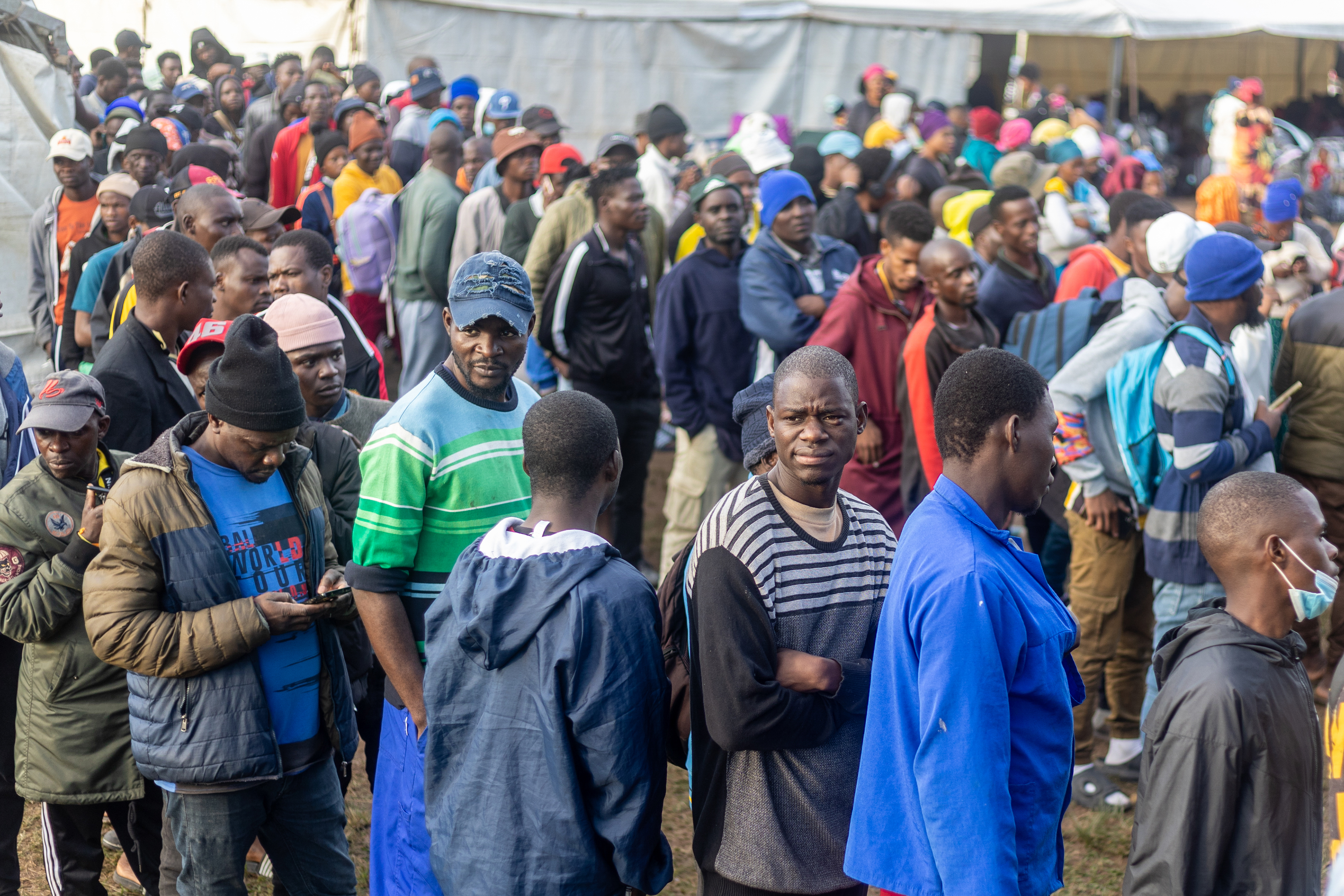epa13028688 Malawi migrants to South Africa line up for supplies in an informal refugee camp in Sherwood, Durban, South Africa, 10 June 2026. Fearing xenophobic attacks, over 1,000 immigrants, mostly from Malawi, have fled their shacks in Burnwood and seek refuge here after South African residents told them to leave on 07 June. EPA/STRINGER