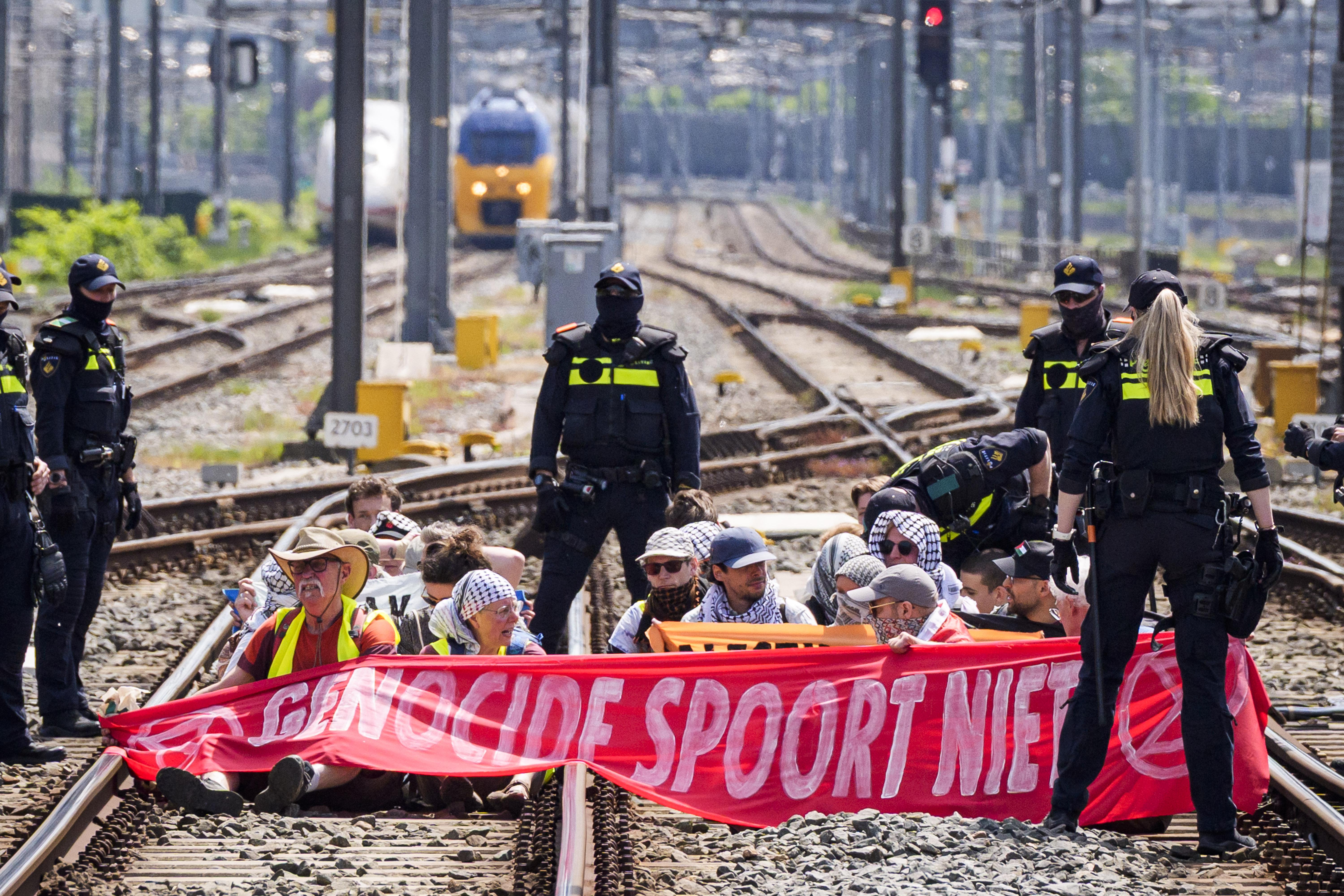 epa12986678 Extinction Rebellion (XR) demonstrators face police officers as they block railway tracks at Utrecht Central Station, Netherlands 23 May 2026. XR activists are protesting the Dutch government's policies regarding the conflict in Gaza and demand the government to impose a full economic embargo on Israel and stop supplying arms. EPA/JEROEN JUMELET