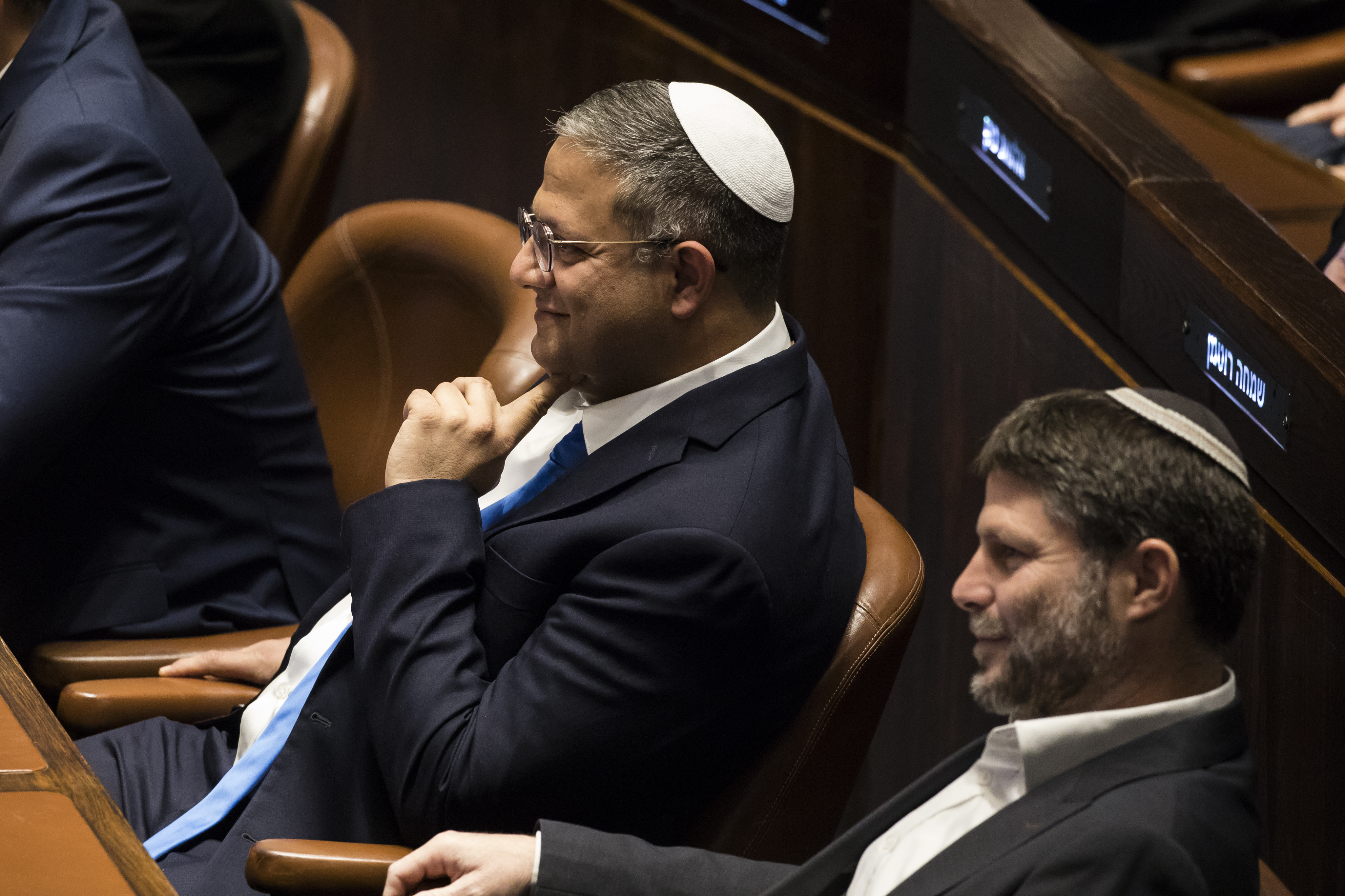 JERUSALEM, ISRAEL - DECEMBER 29: Designated Minister of National Security Itamar Ben Gvir (L) and designated Israeli Minister of Finance Bezalel Smotrich (R) react at the Israeli parliament during a new government sworn in discussion at the Israeli parliament on December 29, 2022 in Jerusalem, Israel. Conservative Benjamin Netanyahu and a bloc of nationalist and religious parties won a clear election victory last month and will be sworn in as government to the Knesset today. This completes Netenyahu's political comeback with a record sixth term in office. (Photo by Amir Levy/Getty Images)
