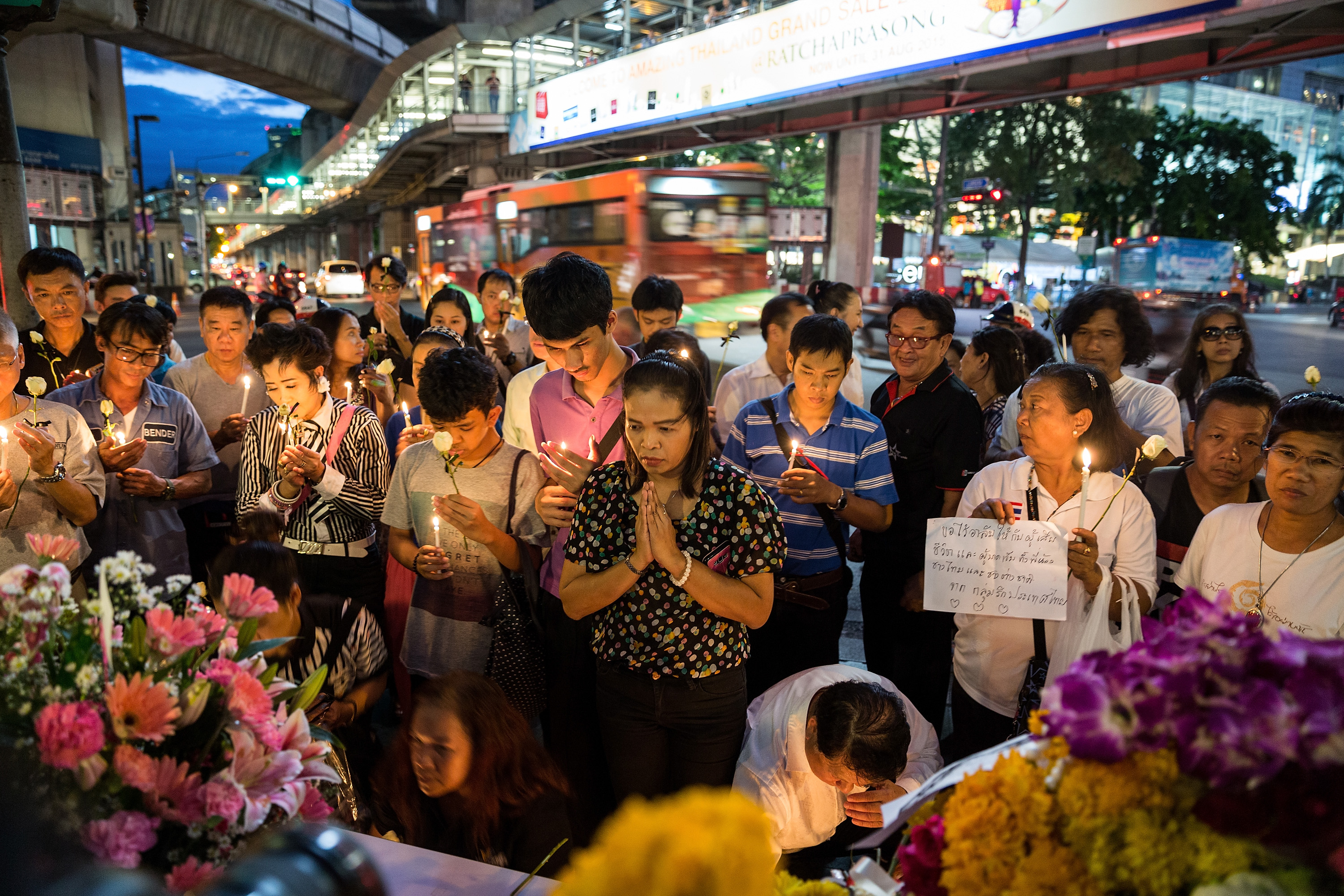 BANGKOK, THAILAND - AUGUST 19: People pray in front the Erawan Shrine on August 19, 2015 in Bangkok, Thailand. On Monday evening Bangkok was hit by what has been described as Thailand's worst ever attack. Security across the country has been stepped up following the explosion which went off near a popular tourist site killing at least 20 people and injuring hundreds more. (Photo by Nicolas Axelrod/Getty Images)