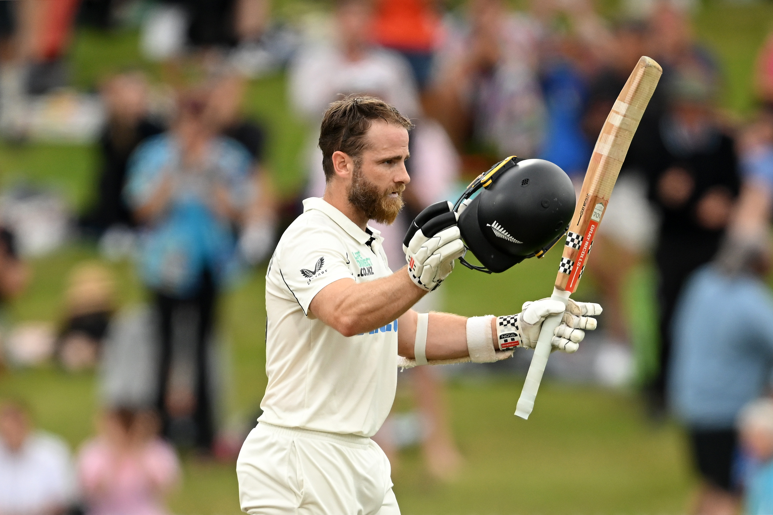 Kane Williamson of New Zealand raises his bat.