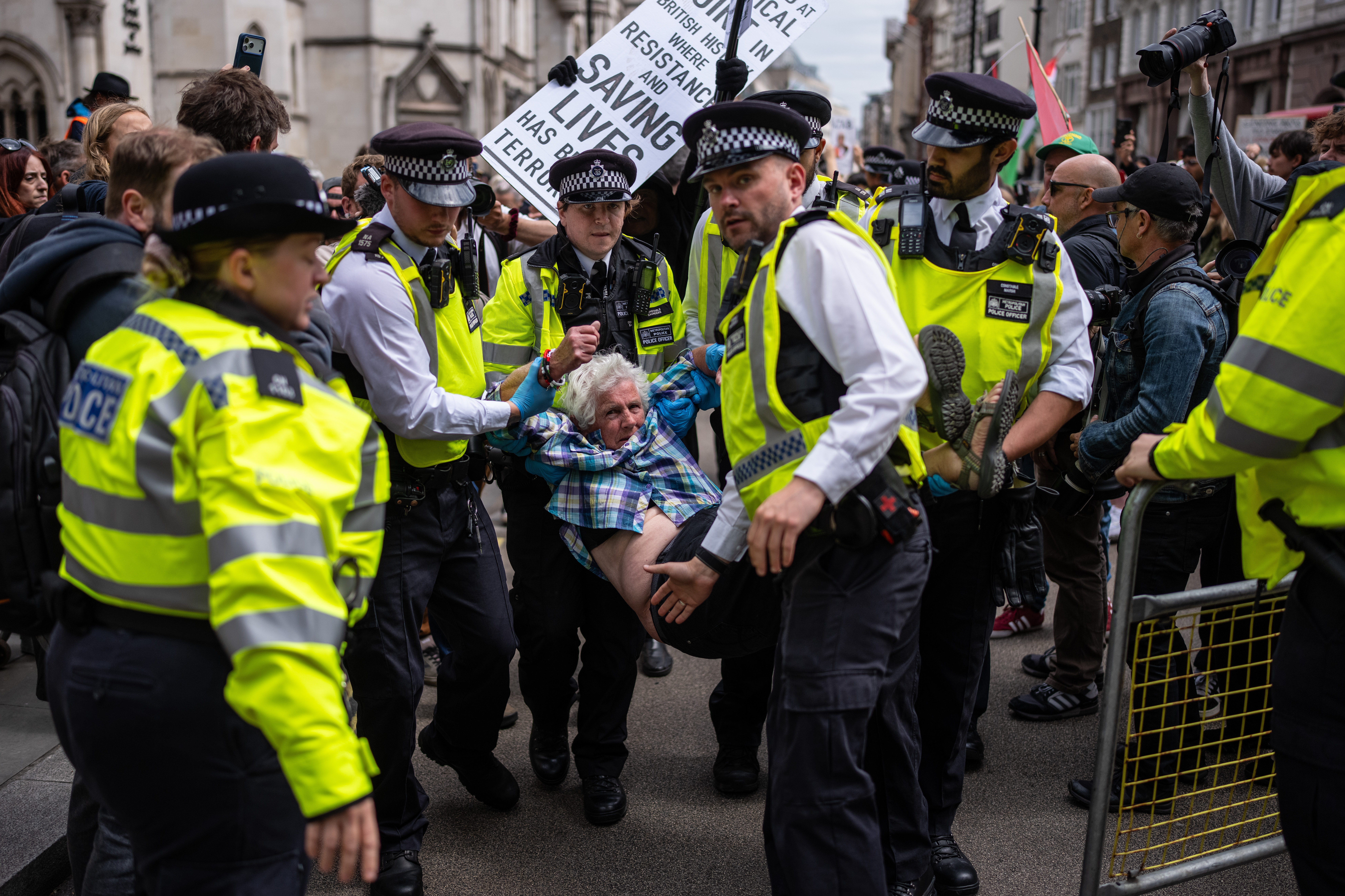 LONDON, ENGLAND - JUNE 15: A woman is detained by police during a demonstration outside the Royal Court's of Justice protest as the Court of Appeal ruled in favour of the Home Office's challenge to the High Court's Palestine Action decision on June 15, 2026 in London, England. The Court of Appeal is handing down judgement on a challenge by the Home Office to the High Court's decision earlier this year that the government's ban of Palestine Action was unlawful. The ban, which took effect July 5, 2025, made membership or support for the direct-action group a criminal offence punishable by up to 14 years in prison. The move triggered protests during which more than 2,000 people were arrested. (Photo by Carl Court/Getty Images)
