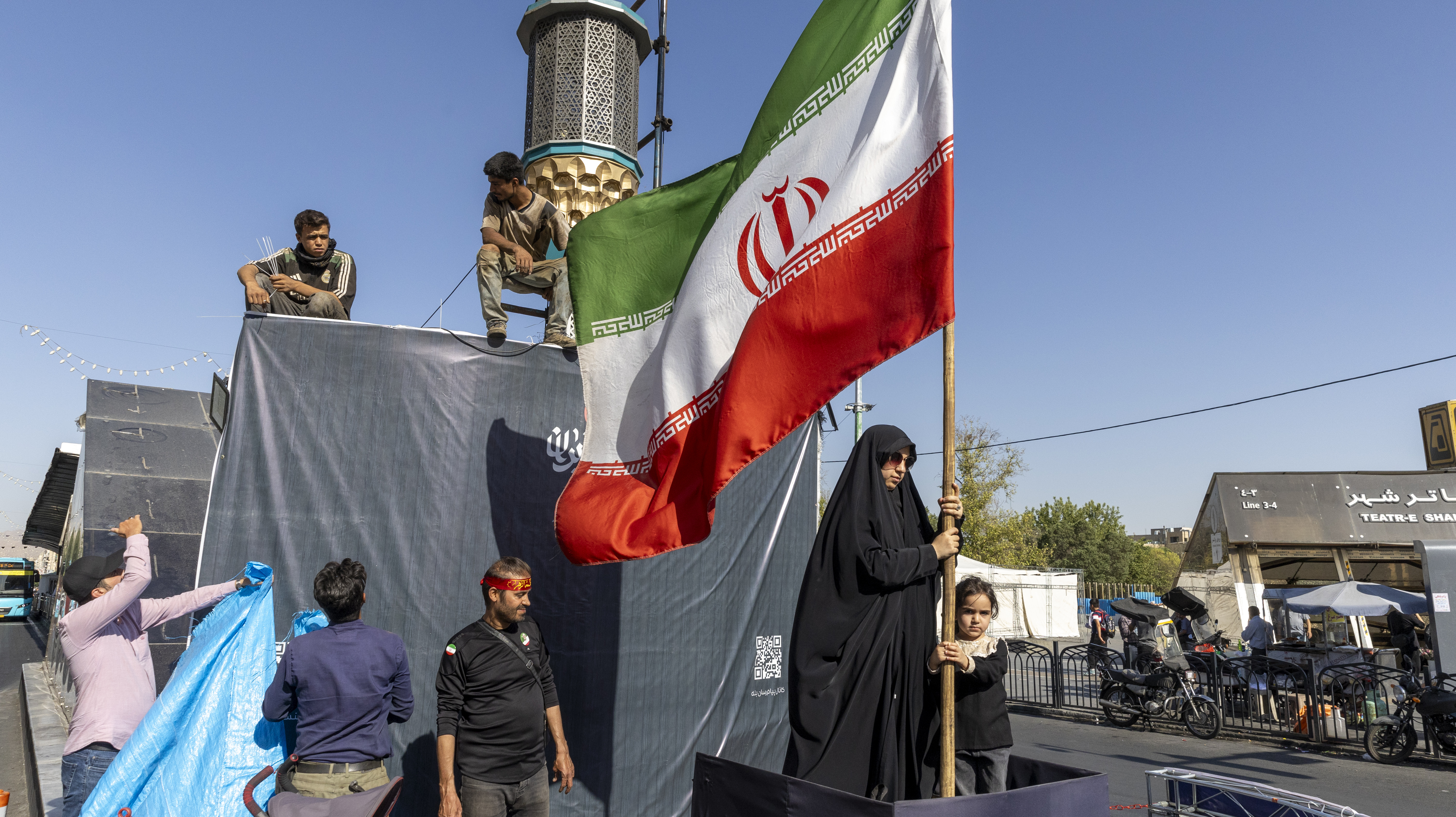 A woman is seen holding the Iranian flag.