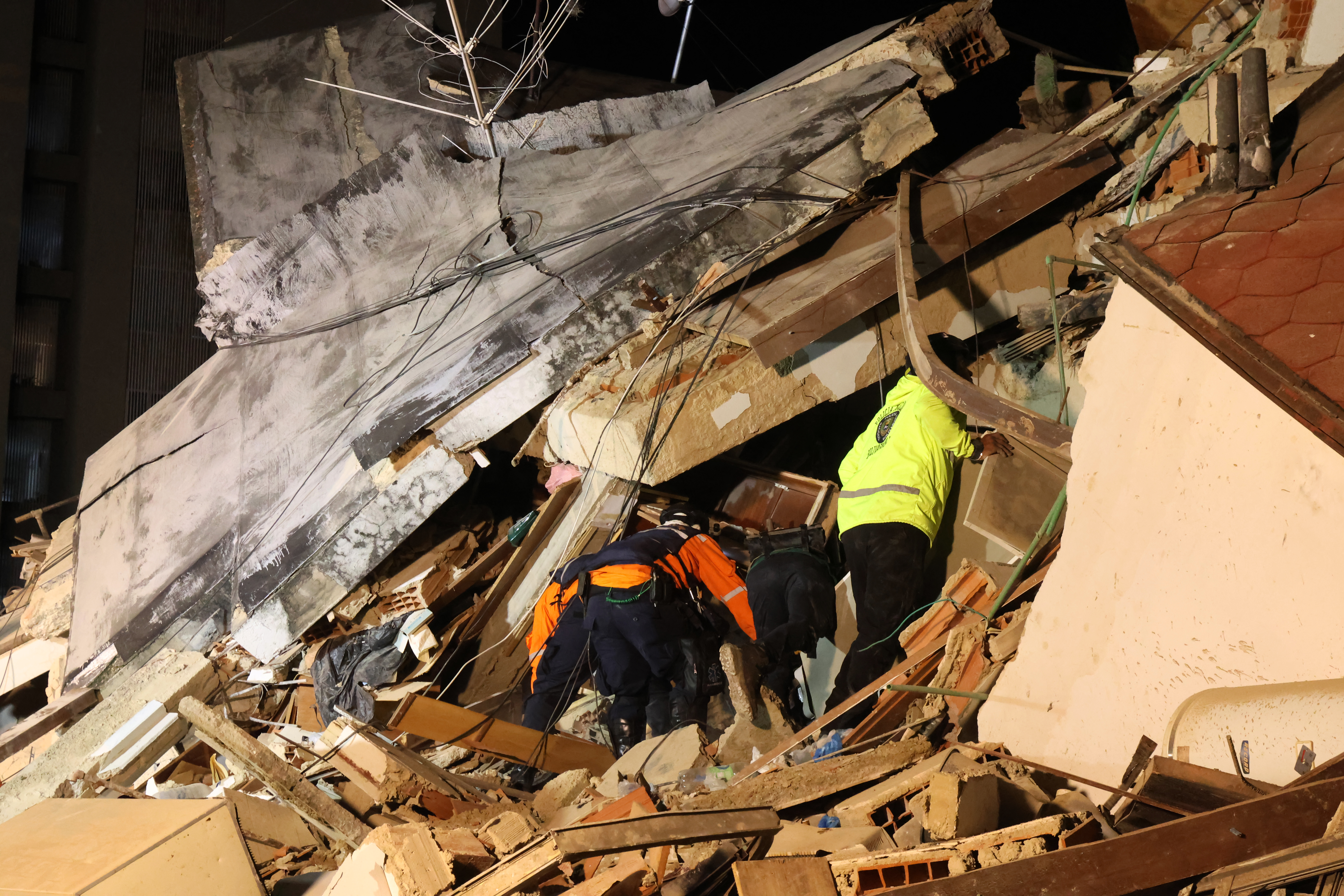 CARACAS, VENEZUELA - JUNE 24: Police members and responders search for victims in a demolished building at Los Palos Grandes after a magnitude 7.2 earthquake struck Venezuela and other regions in the Caribbean on June 24, 2026 in Caracas, Venezuela. According to the U.S. Geological Survey (USGS), the main earthquake was followed by a 7.5-magnitude aftershock less than a minute later; although some buildings collapsed, the number of victims remains unknown. (Photo by Edilzon Gamez/Getty Images)