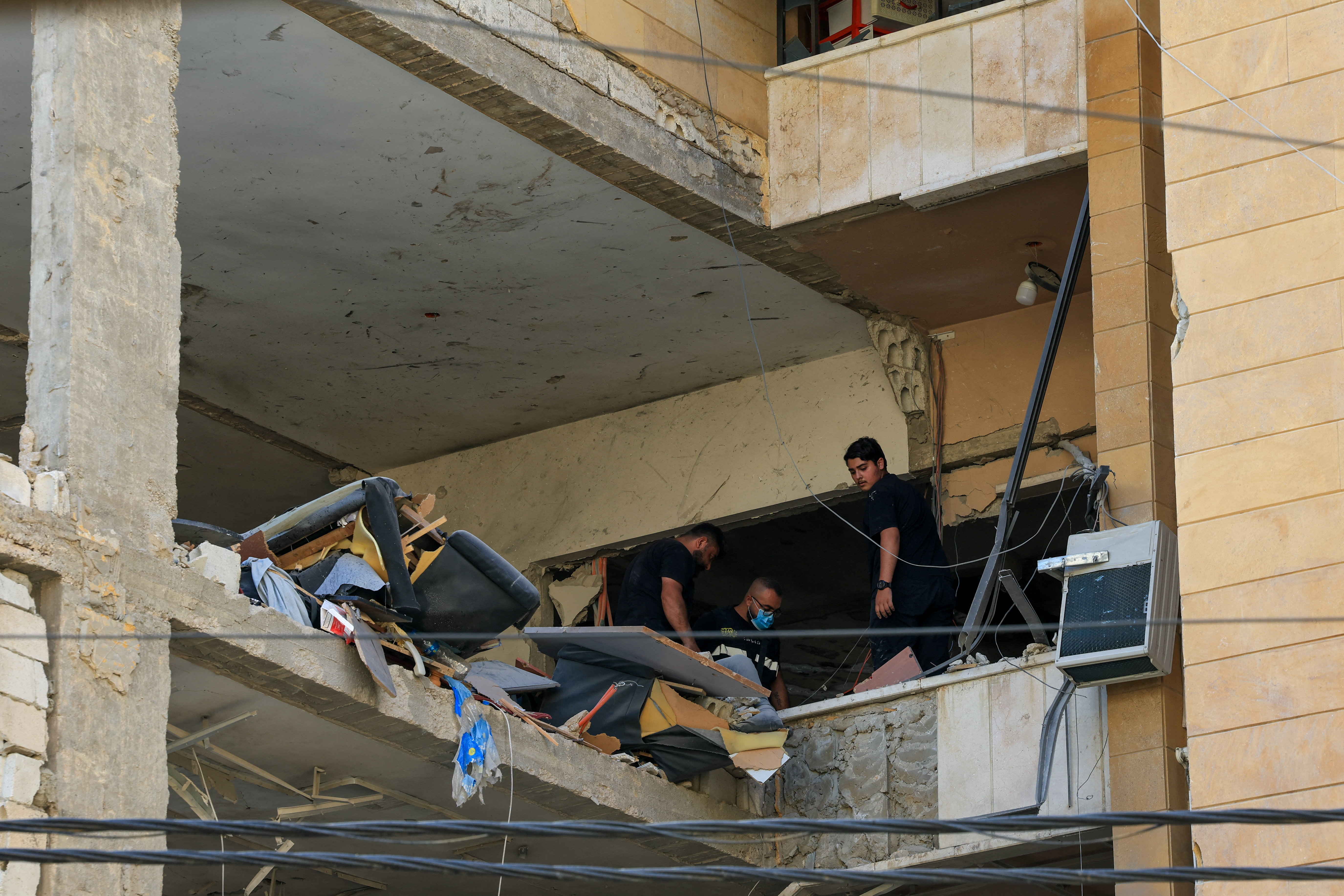 People stand inside a damaged building following an Israeli strike on the southern suburbs of Beirut, Lebanon, June 7, 2026. REUTERS/Mohamed Azakir