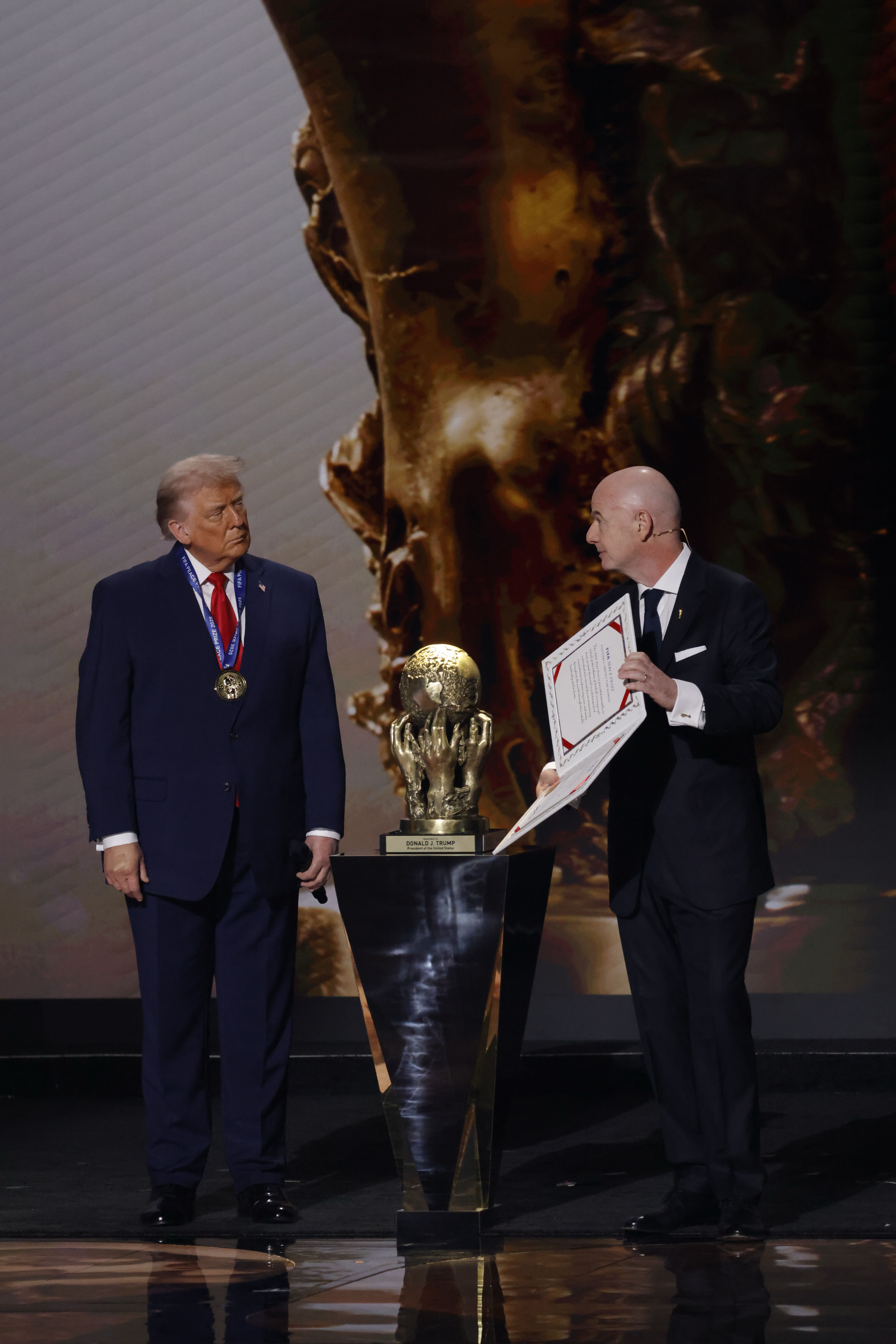 Dec 5, 2025; Washington, District of Columbia, USA; U.S. President Donald Trump (L) receives the FIFA Peace Prize from FIFA President Gianni Infantino (R) during the FIFA World Cup 2026 Final Draw at John F. Kennedy Center for the Performing Arts. Mandatory Credit: Amber Searls-Imagn Images