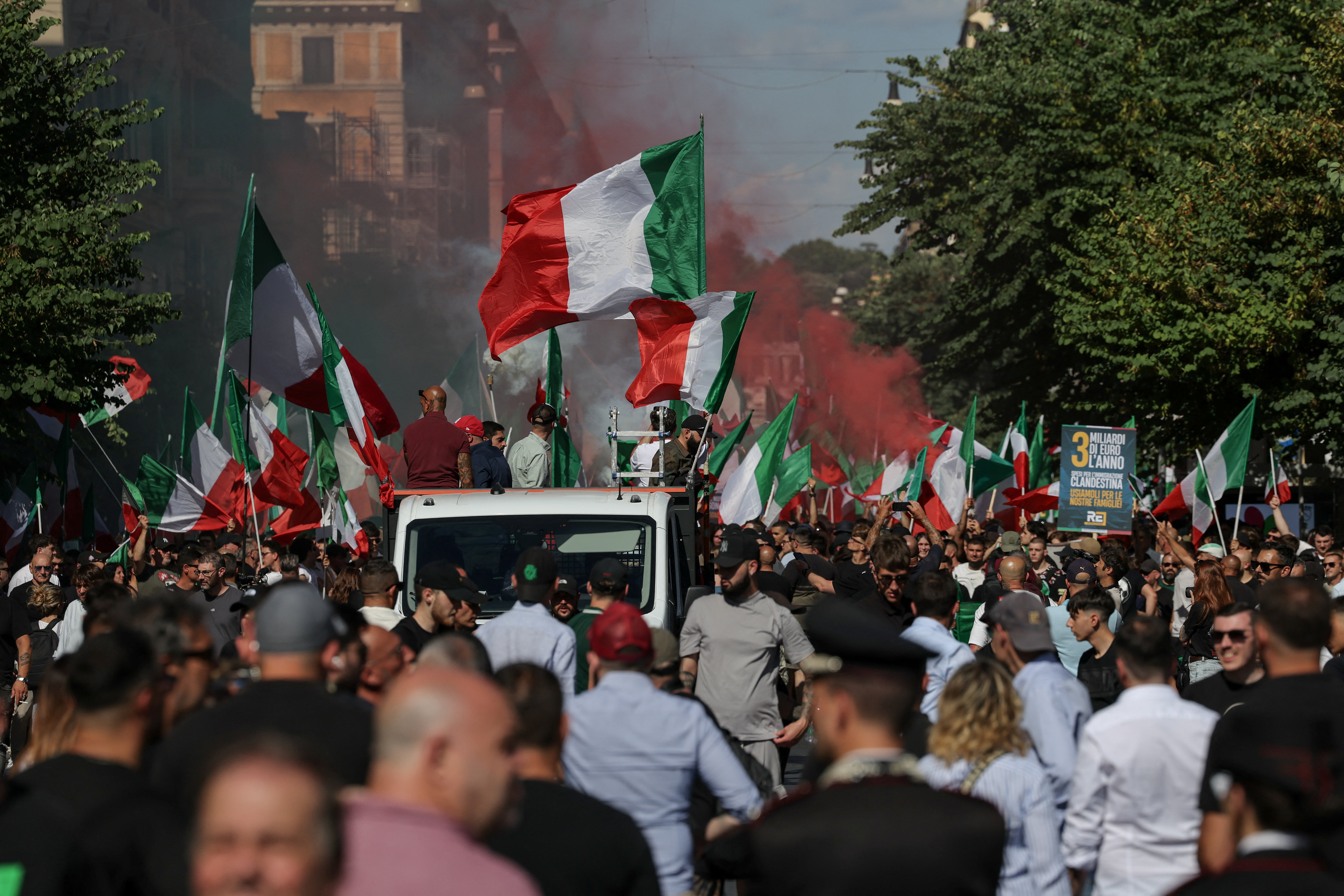Demonstrators wave Italian flags as red smoke rises during a “remigration” march in Rome, Italy, June 13, 2026. The march was organized by the “Remigration and Reconquest” committee in support of a proposed law calling for the forced return of irregular migrants to their countries of origin and drew far-right activists from across Italy. REUTERS/Francesco Fotia