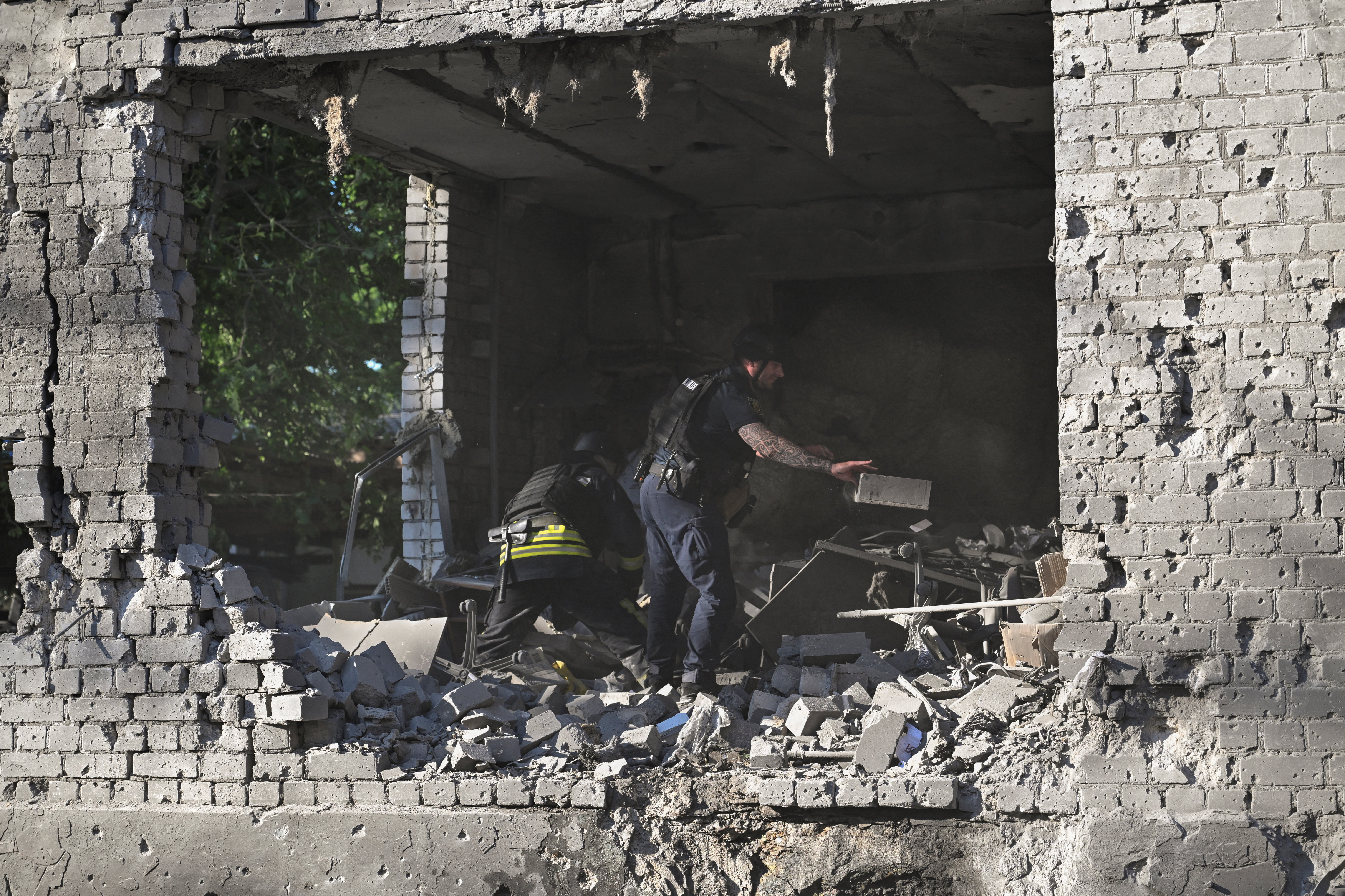 A police officer and a rescuer remove debris at the site of an administrative building that was hit by a Russian airstrike, amid Russia's attack on Ukraine, in Zaporizhzhia, Ukraine, June 20, 2026. REUTERS/Stringer
