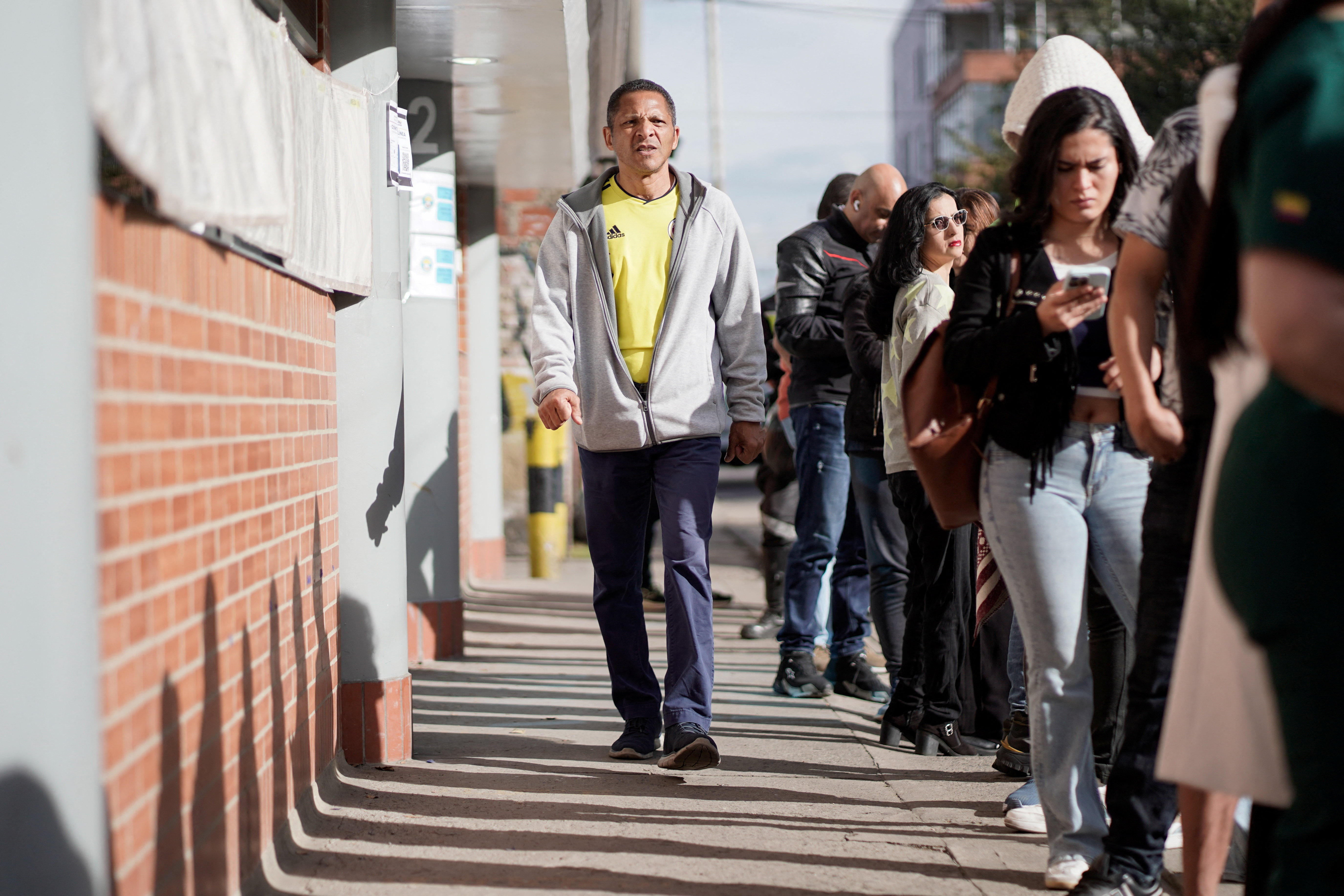 People line up outside a polling station to vote in a runoff between right-wing presidential candidate Abelardo De La Espriella and leftist candidate Ivan Cepeda, in Bogota, Colombia, June 21, 2026. REUTERS/Sergio Acero