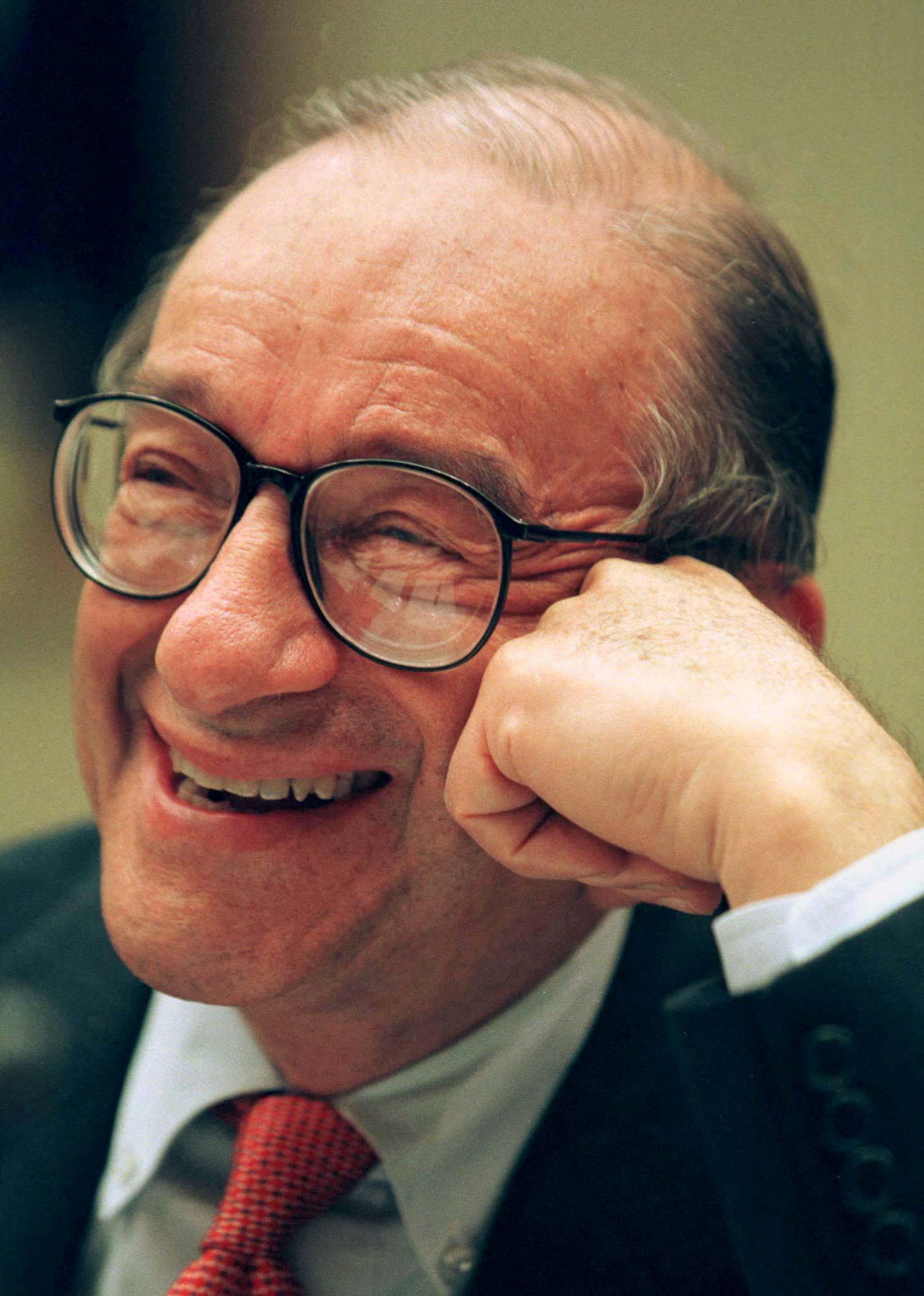 FILE PHOTO: Federal Reserve Chairman Alan Greenspan jokes with House Commerce subcommittee members during testimony July 17. Greenspan said he backs tight limits on the ability of commercial companies to own banks. REUTERS/Gary Cameron/File Photo