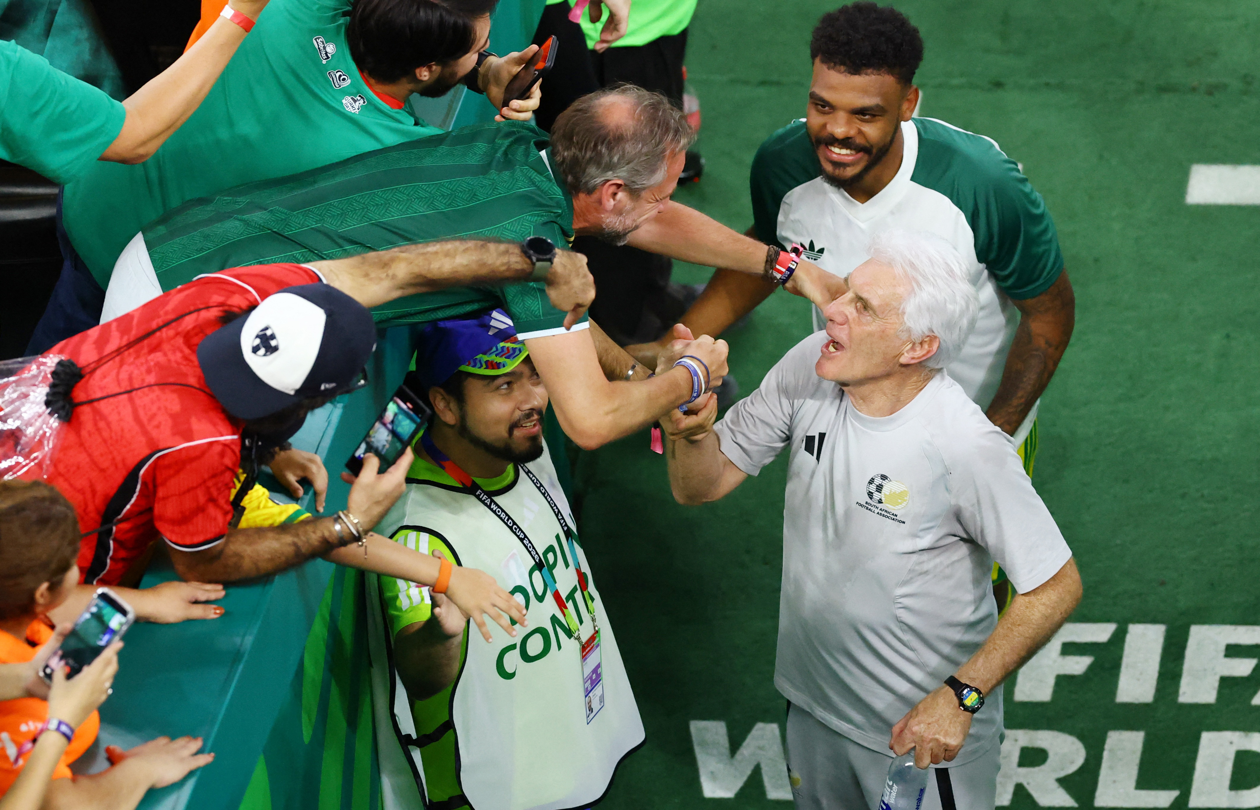 Soccer Football - FIFA World Cup 2026 - Group A - South Africa v South Korea - Estadio Monterrey, Monterrey, Mexico - June 24, 2026 South Africa coach Hugo Broos celebrates with fans after the match REUTERS/Raquel Cunha