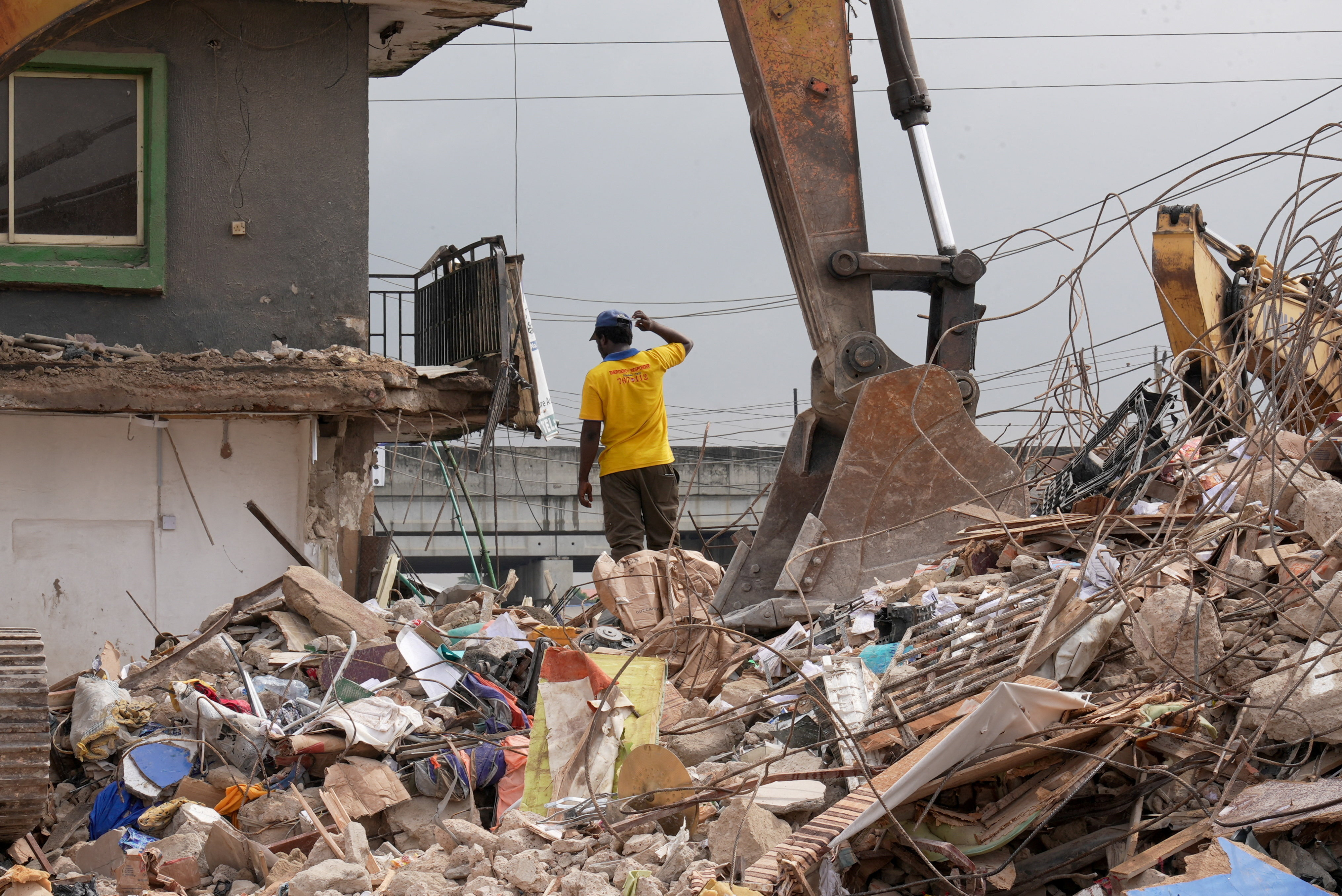 A rescue worker searches through the rubble of a building that collapsed June 25, killing at least nine people, according to the state's commissioner for information, in Lagos, Nigeria, June 26, 2026. REUTERS/Kazeem Sanni REFILE - CORRECTING INFORMATION FROM "BUILDING THAT COLLAPSED JUNE 23" TO "BUILDING THAT COLLAPSED JUNE 25".
