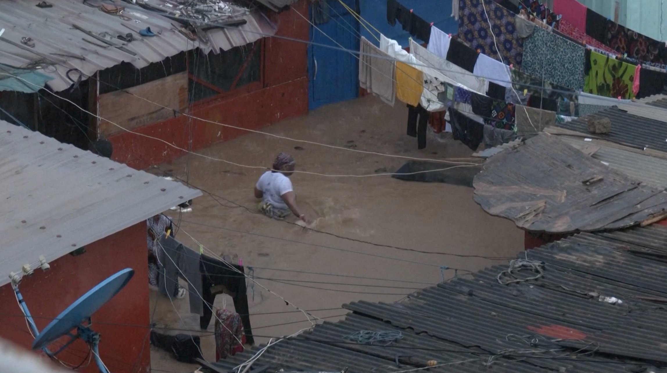 A person wades through floodwaters, in Accra, Ghana, in this still image taken from a video, June 29, 2026. Reuters TV via REUTERS