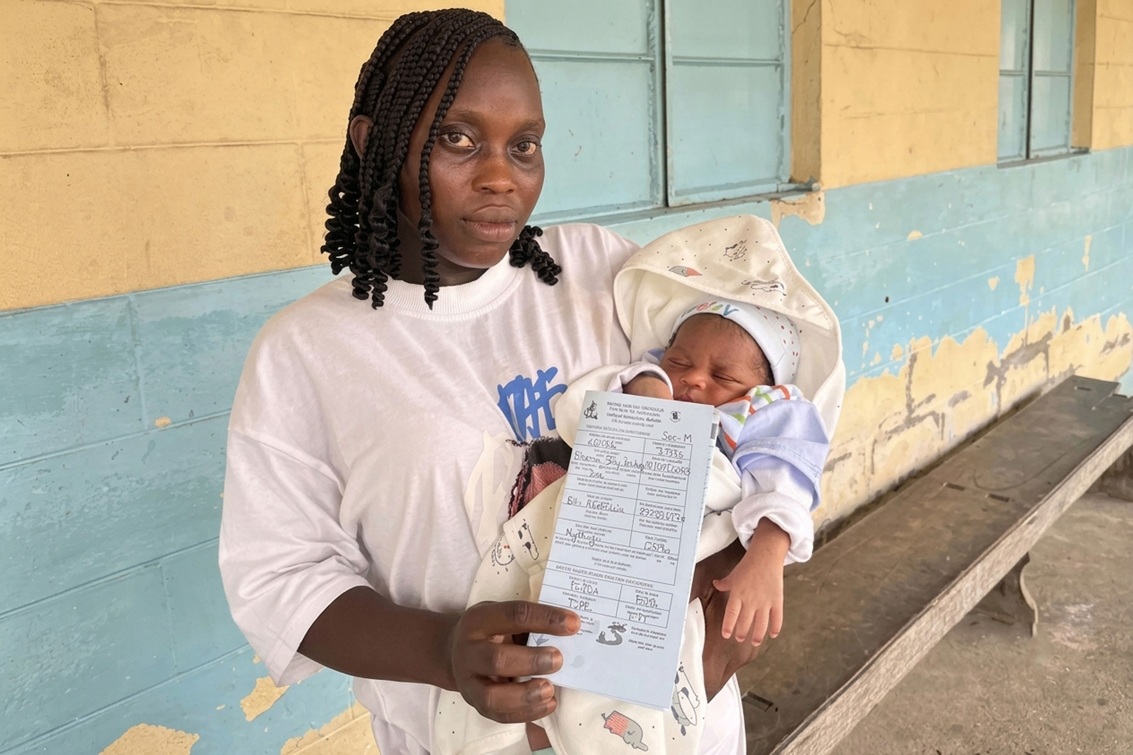 of Cameroon, holds her newborn baby born on (1). She was able to secure the child's birth certificate immediately without any bureaucratic delays [Joy Nforshi Bah _ UNICEF]