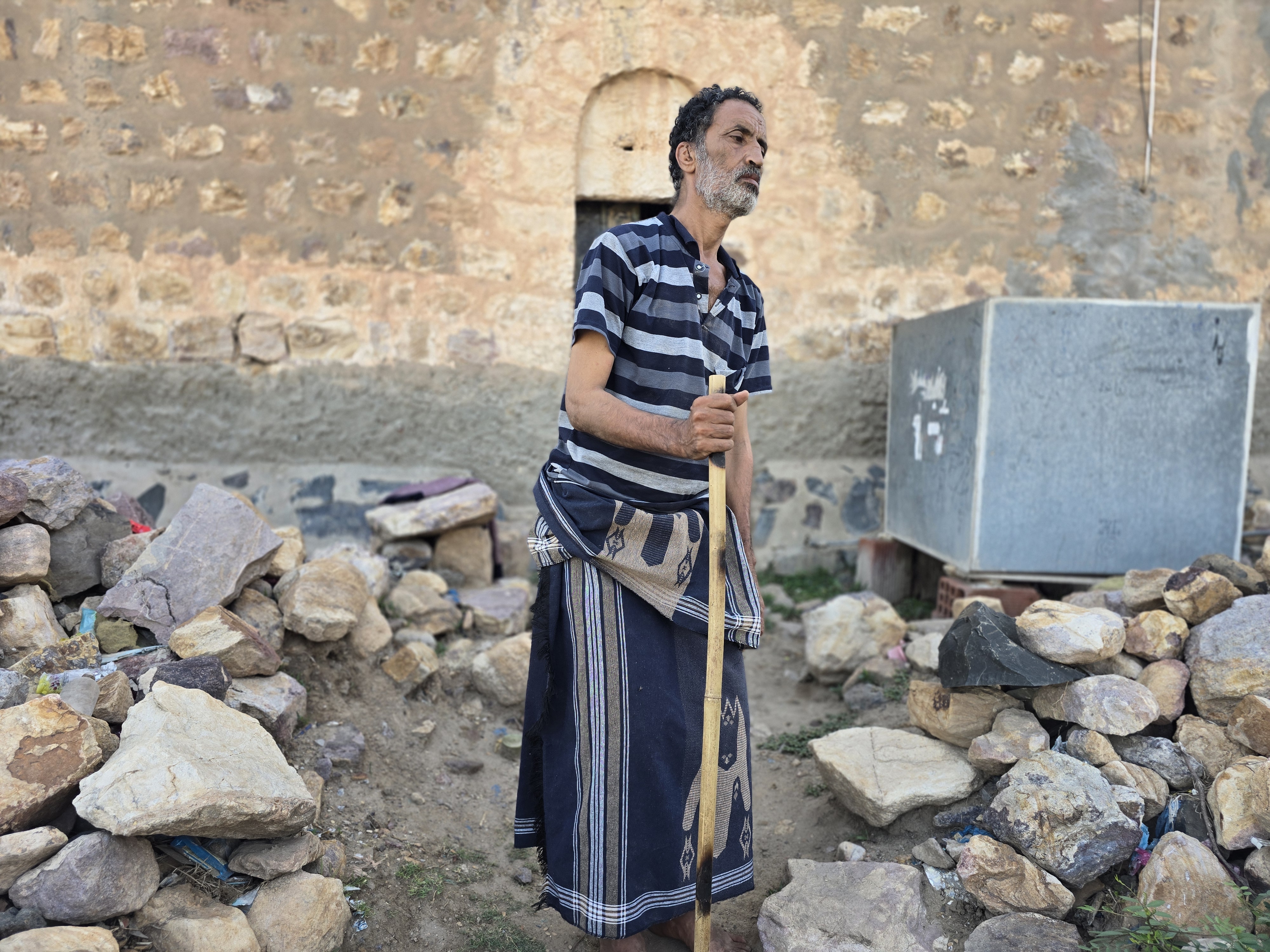 Ahmed Nagi, who is in his 50s, can barely walk without a cane and cannot access the medical care he needs [Nasser al-Sakkaf/Al Jazeera]