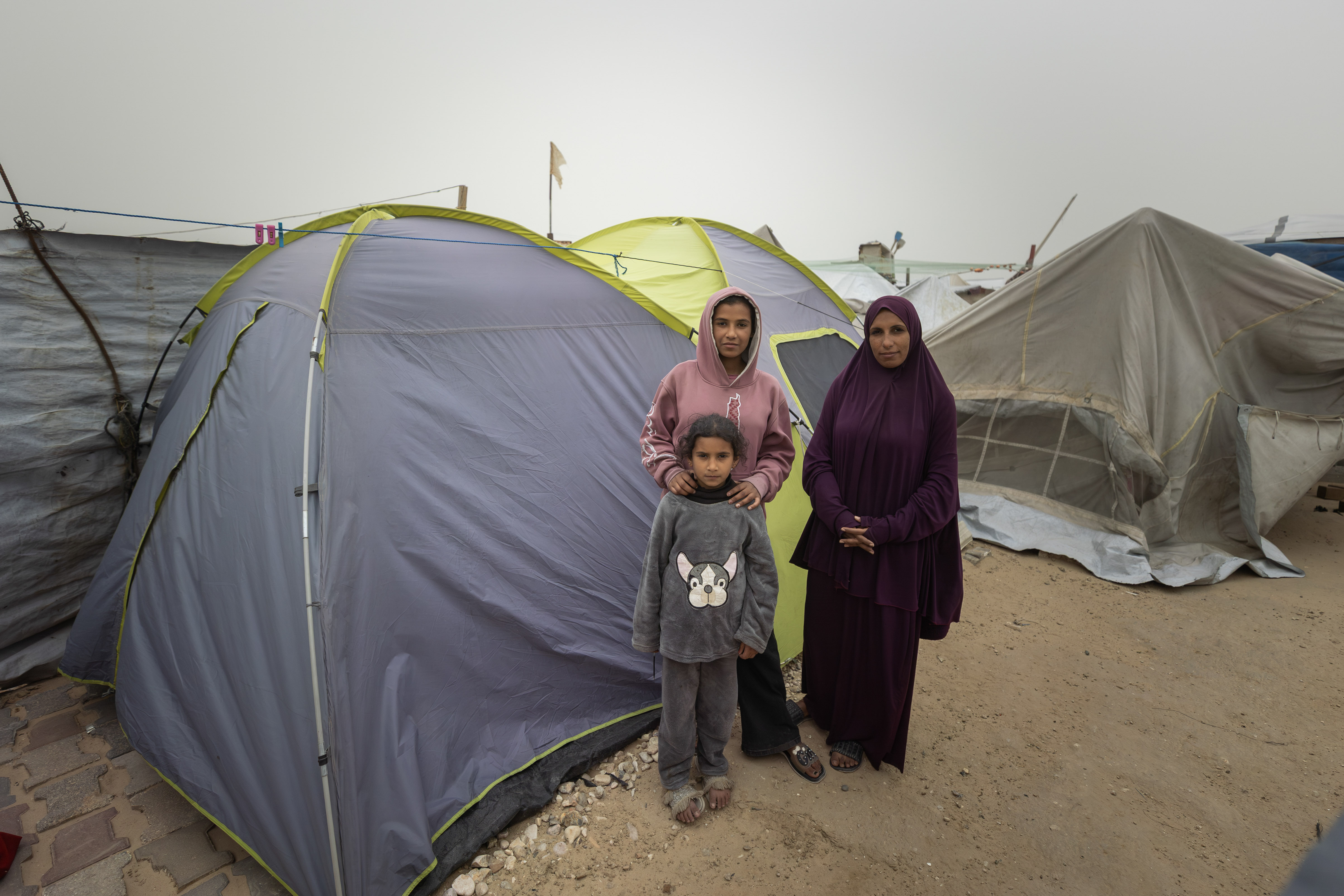 “I try with all my might to provide a decent life for my children. I defy displacement and the dire economic situation,” says Asmaa Shtewi. Asmaa and her two daughters were displaced from southeastern Gaza city to the Gaza Port, where the shelter in weak tents made for camping. She used to work as a theatre actor, but her most challenging role now is playing both mother and father for her two children.