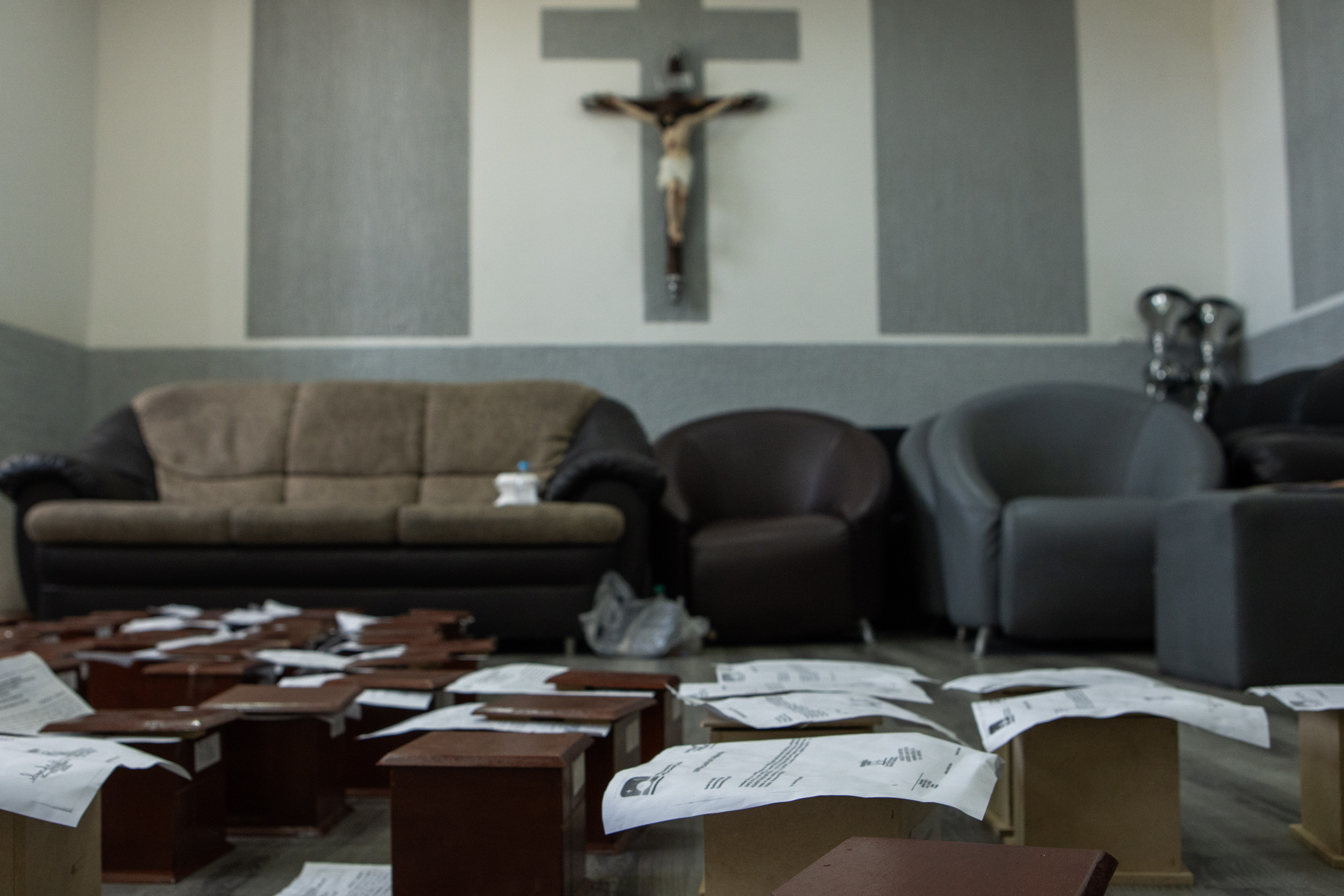 Small wooden boxes line the floor containing the remains of those who have been identified and cremated at the funeral home in La Guaira