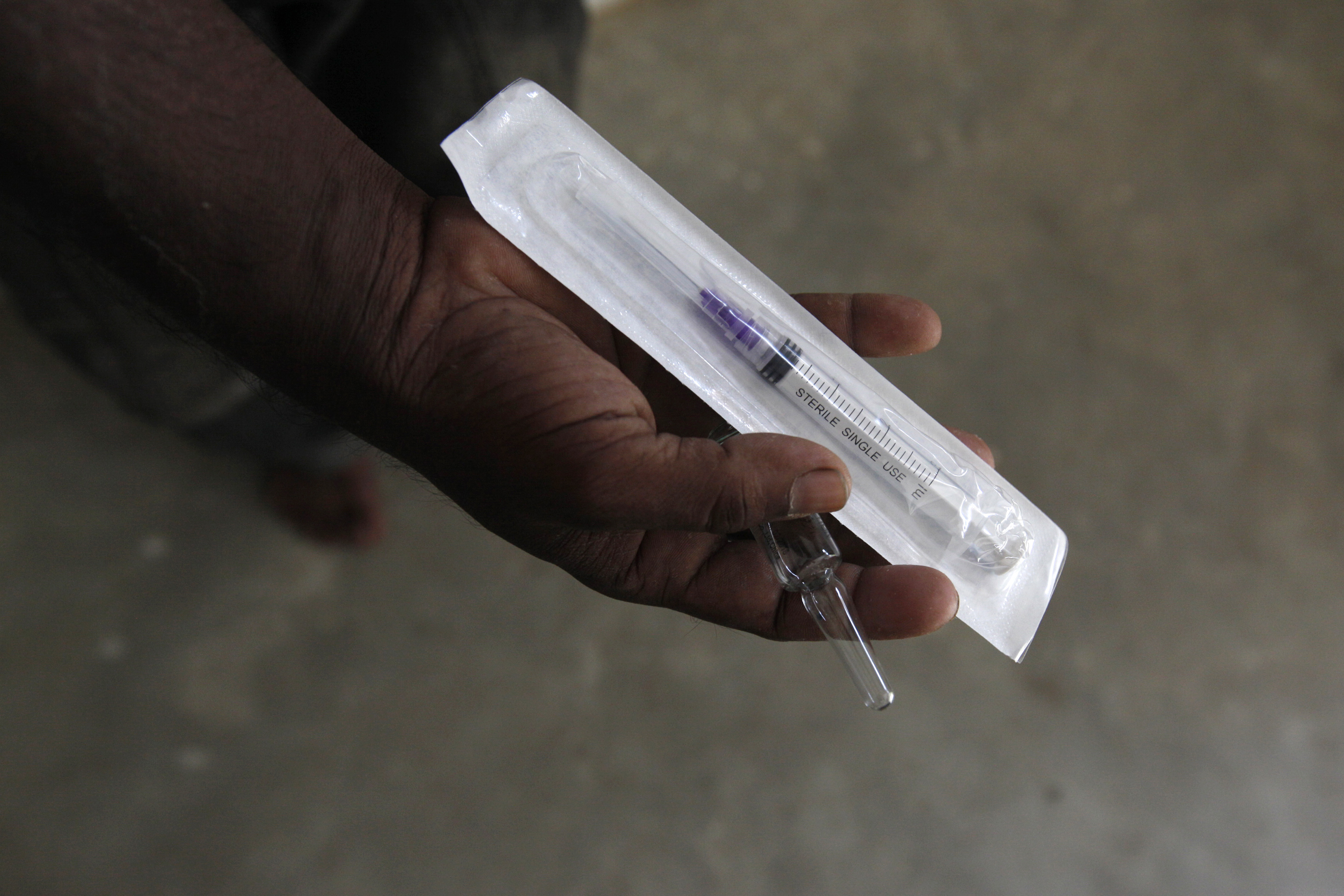 A HIV patient displays a new syringe and distilled water he received at Pakistan Society, a non-governmental organization (NGO) Drop-In Centre in Karachi November 30, 2013. People around the world will observe World AIDS Day on December 1. REUTERS/Akhtar Soomro (PAKISTAN - Tags: HEALTH SOCIETY)