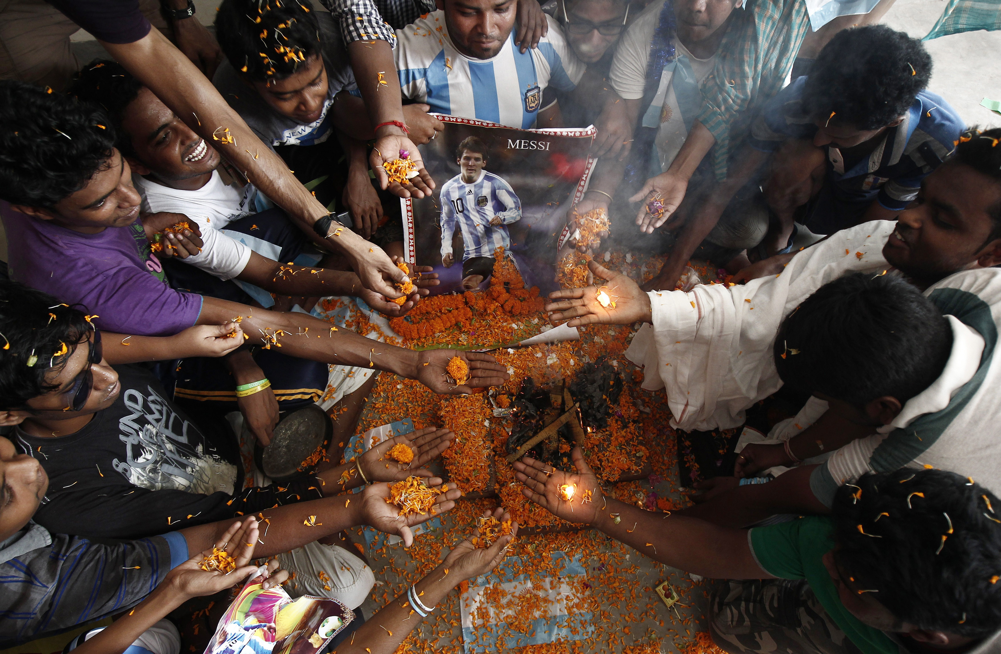 Argentina football fans perform a special prayer, 'Yagna' or a Hindu ritual for the success of their team next to a picture of Lionel Messi ahead of the team's World Cup group match against Bosnia and Herzegovina, in Kolkata, on June 15, 2014 [Rupak De Chowdhuri/Reuters]