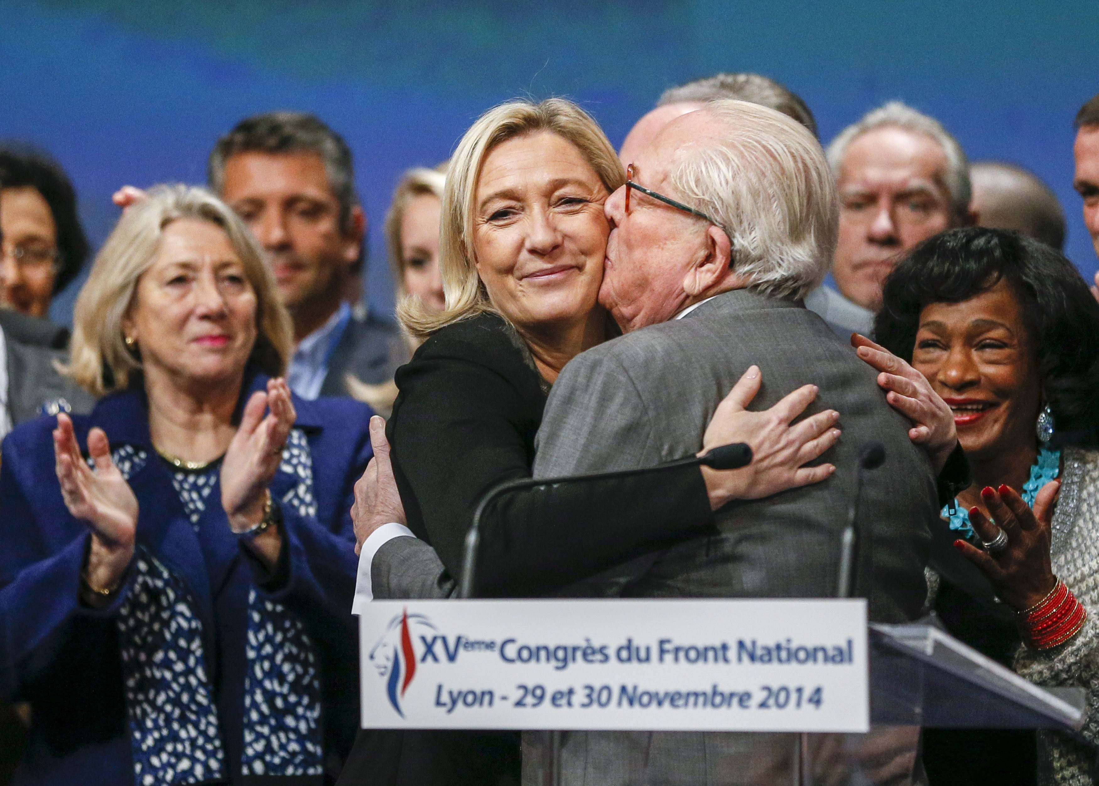 Marine Le Pen (C), France's National Front political party leader, reacts with her father Jean-Marie Le Pen (R) after being re-elected during their congress in Lyon November 30, 2014. REUTERS/Robert Pratta (FRANCE - Tags: POLITICS TPX IMAGES OF THE DAY)