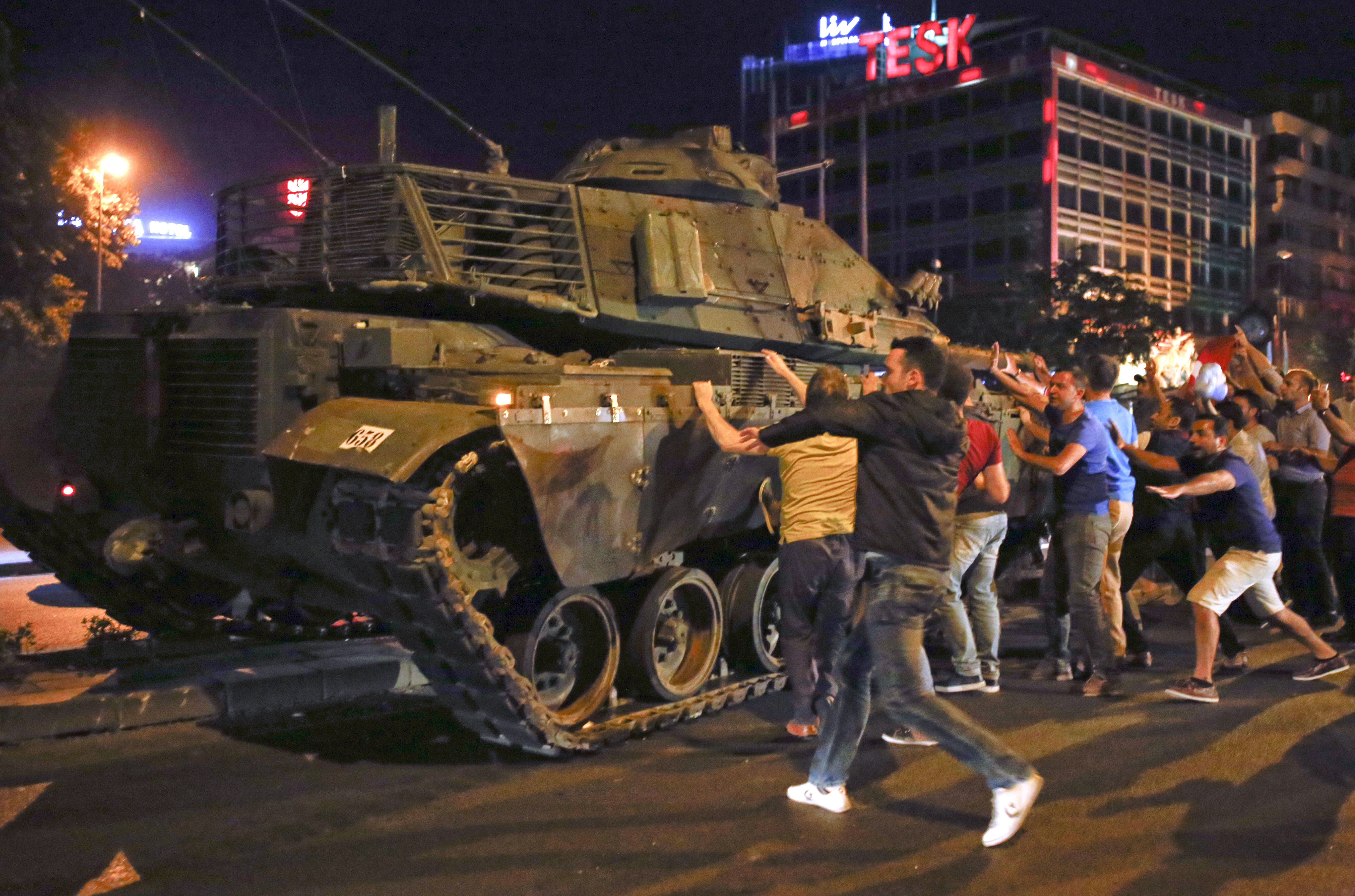 People react near a military vehicle during an attempted coup in Ankara, Turkey, July 16, 2016