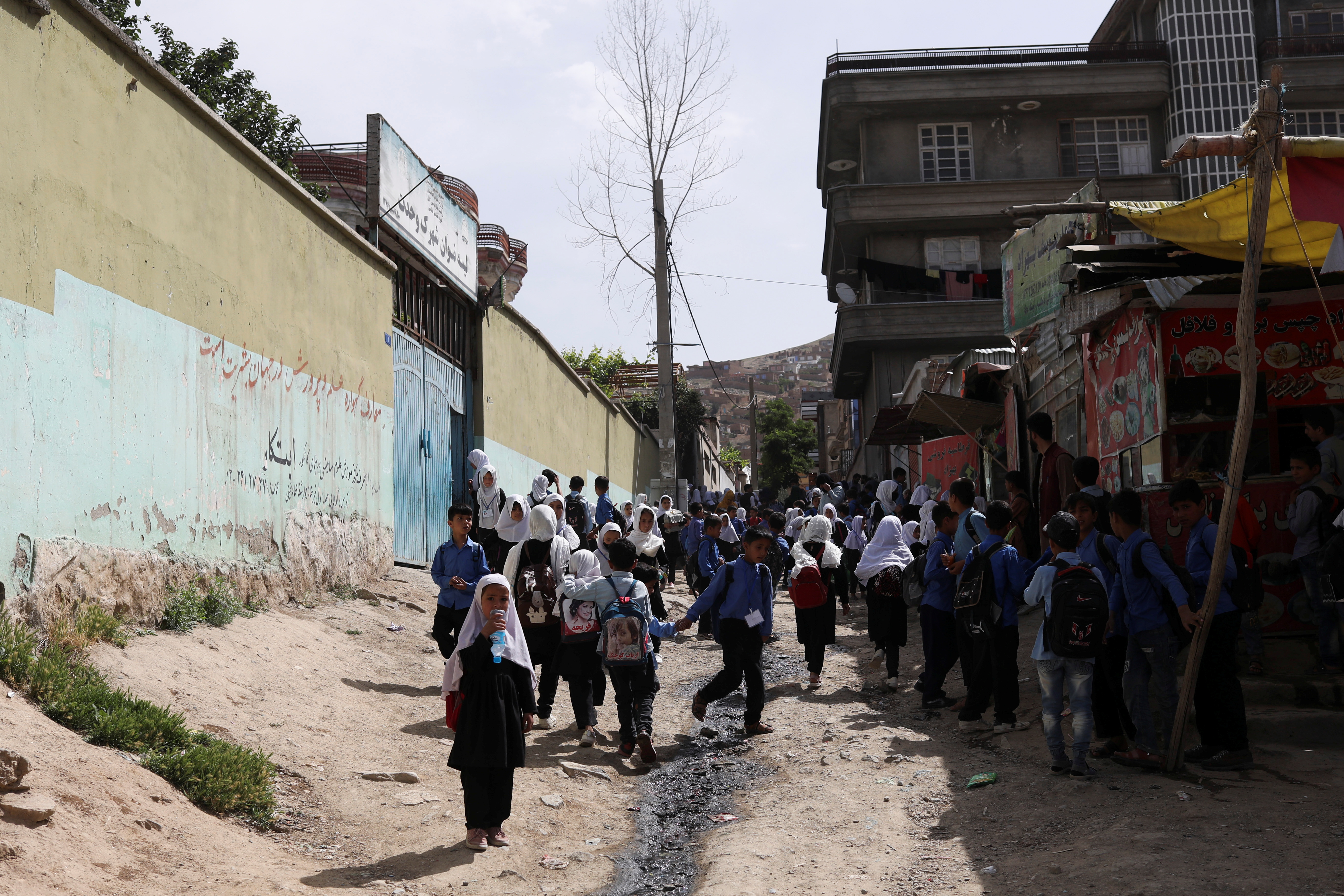 Afghan students are seen in front of a school in Kabul, Afghanistan, May 10, 2022. REUTERS/Ali Khara