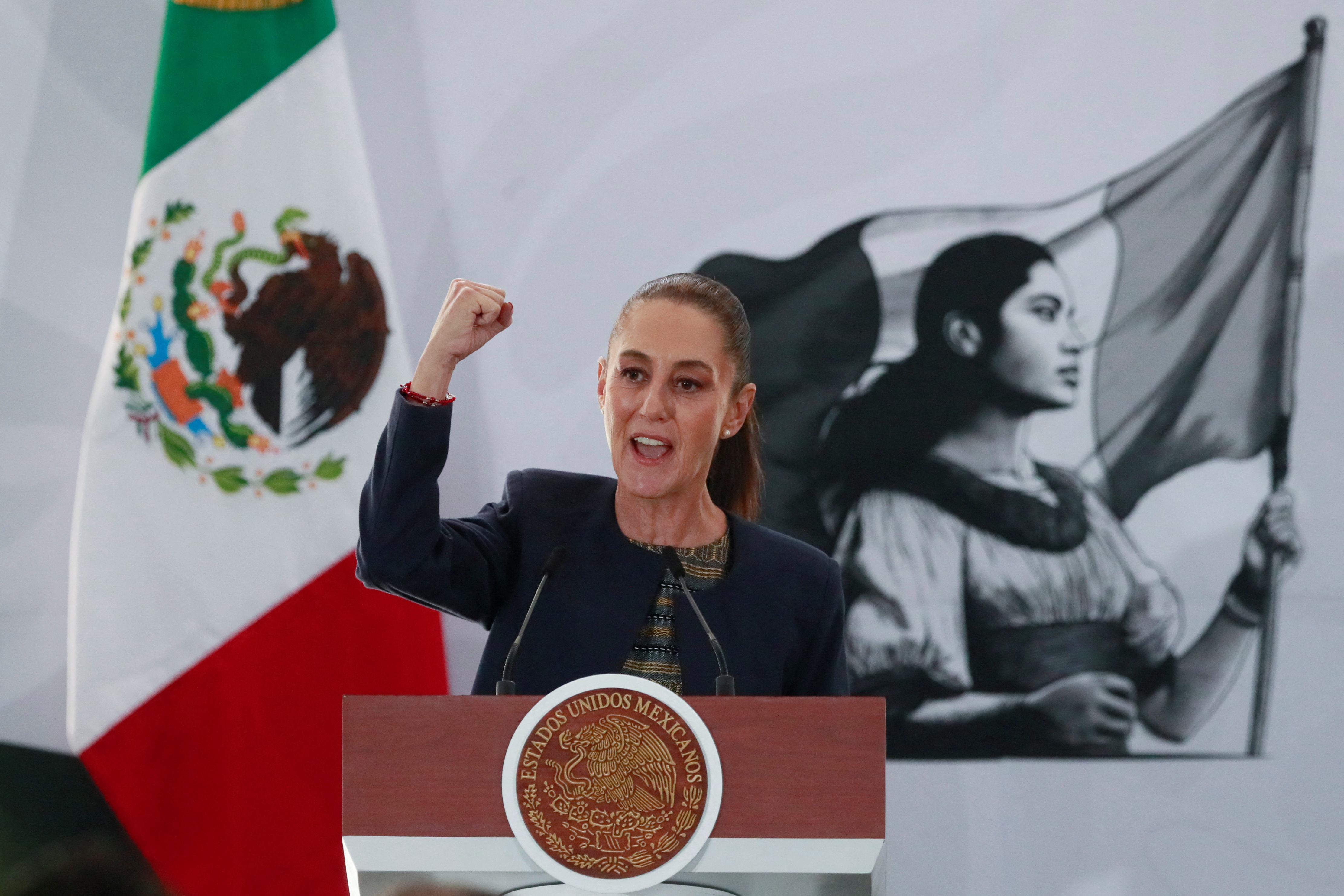 Mexico's President Claudia Sheinbaum raises her fist while speaking at an event in Mexico City on March 18, 2025 [Henry Romero/Reuters]