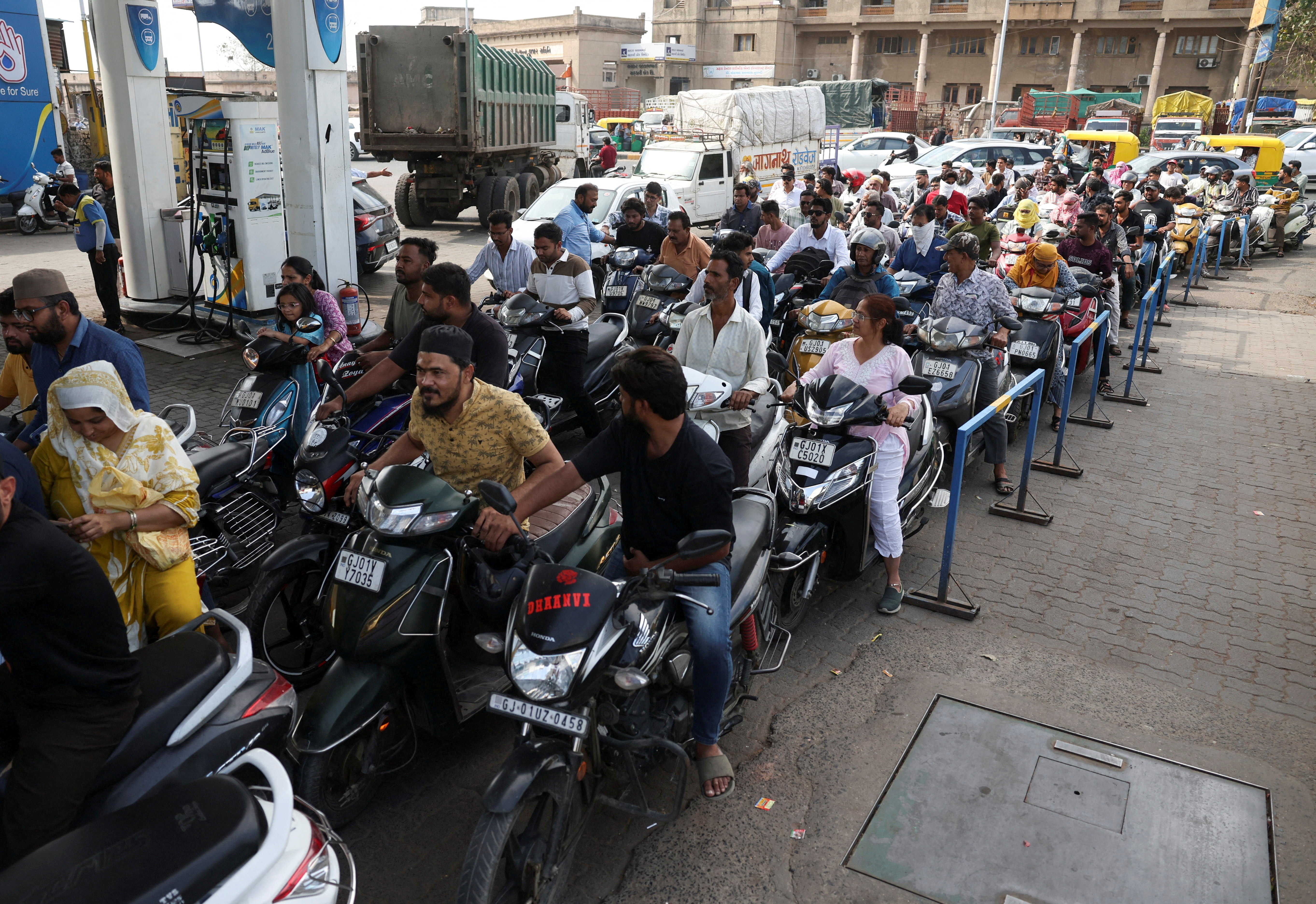 People queue to fill petrol in their two-wheelers with concerns over potential supply disruptions, but authorities say there are no shortages, amid the ongoing U.S.-Israeli conflict with Iran, in Ahmedabad, India, March 23, 2026. REUTERS/Amit Dave