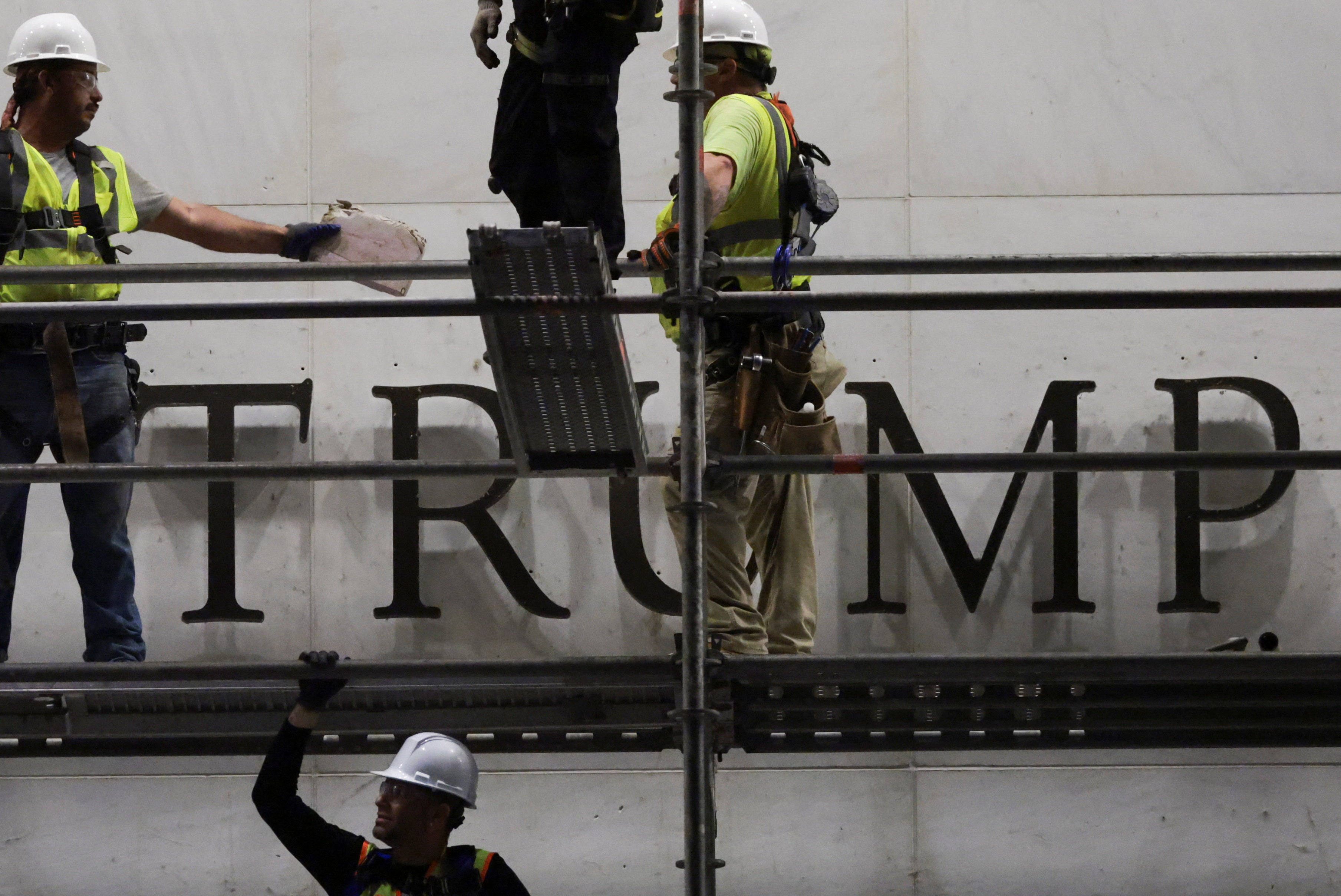 Workers stand on a building