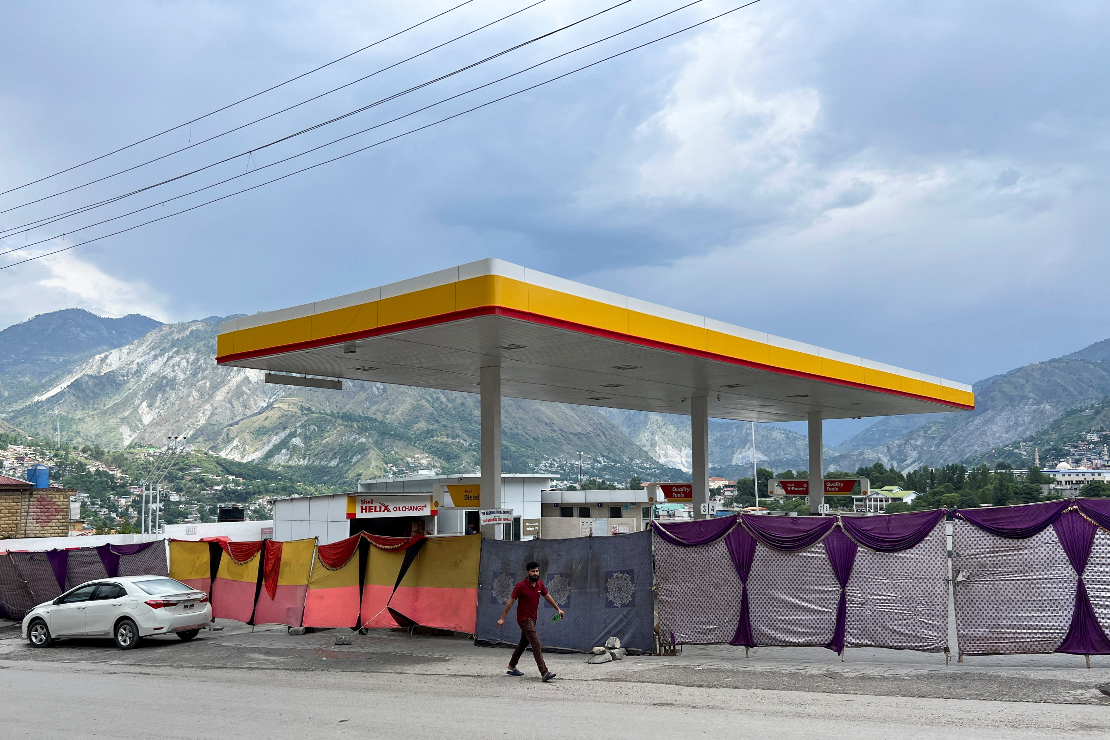 A man walks past a closed fuel station with the entrance blocked off by a cloth in the background, during a shutdown strike called by the recently banned Joint Awami Action Committee (JAAC), an alliance of civil society groups, in Muzaffarabad, Pakistani Kashmir, June 19, 2026. Picture taken with a mobile phone. REUTERS/Naseer ud Din