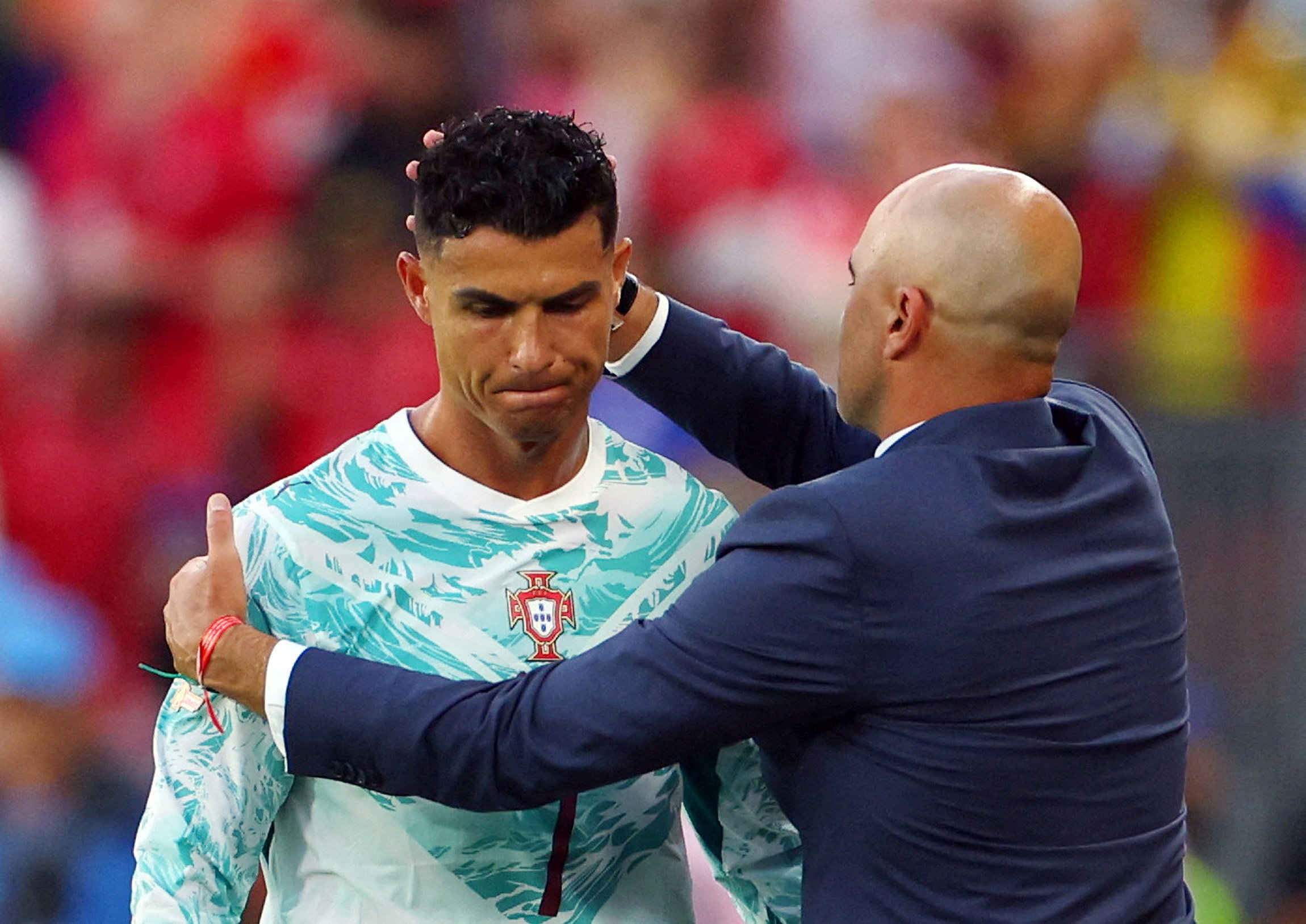 Cristiano Ronaldo with coach Roberto Martinez as he reacts after being substituted off