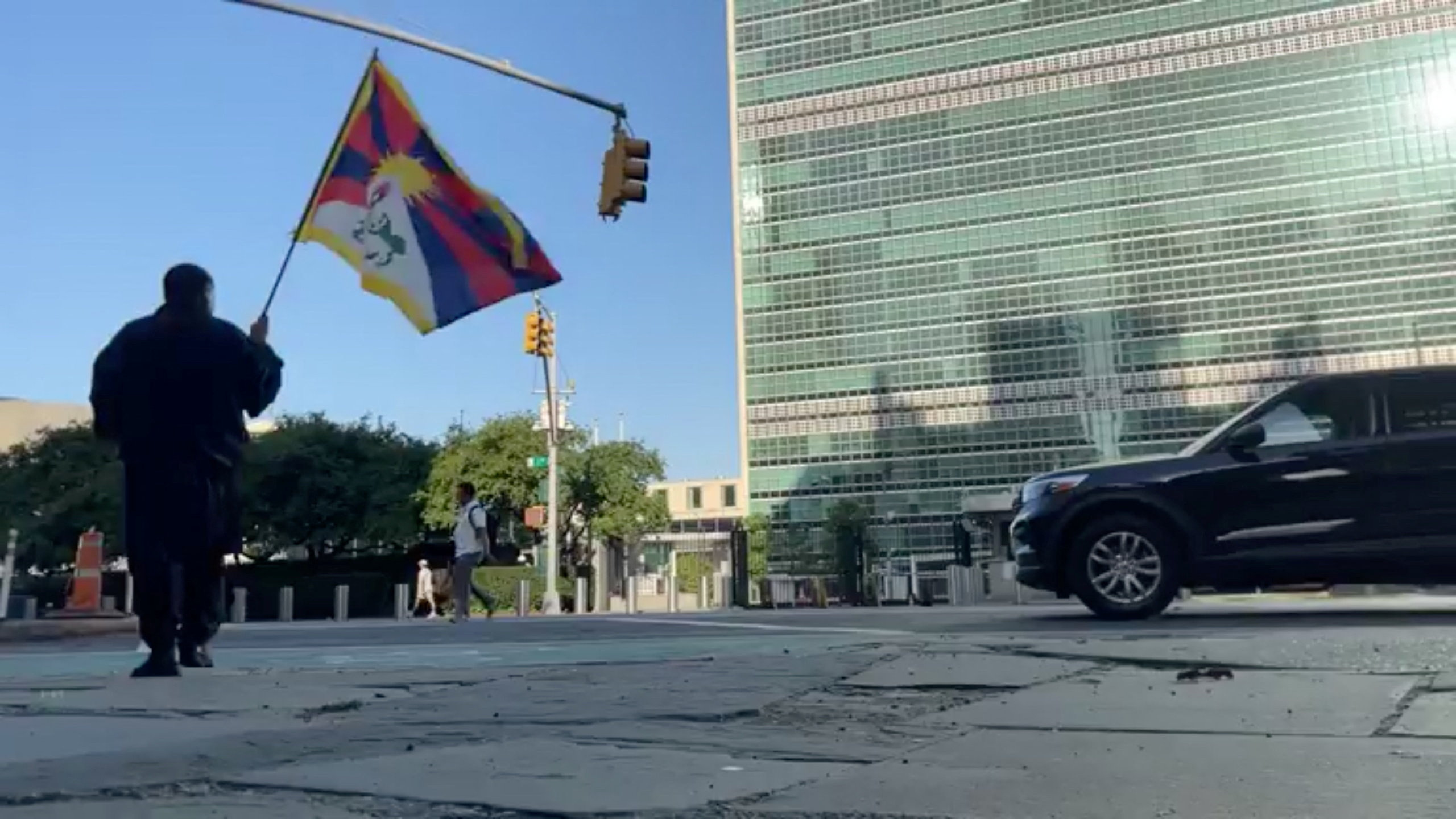 A man identified as Tibetan activist Lobga Rangzen walks carrying a Tibetan flag near the UN headquarters in New York, US on July 2, 2026.
