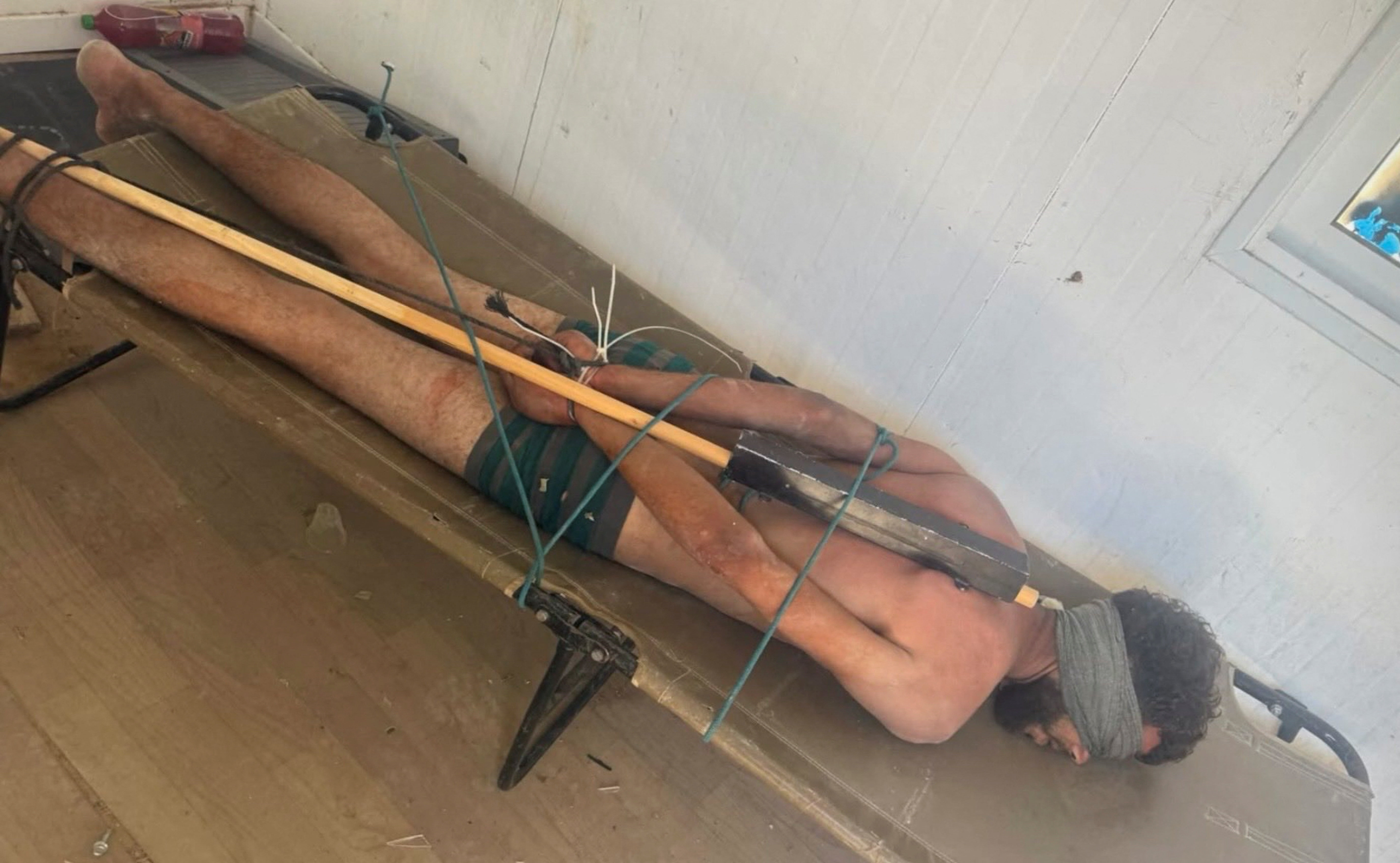 A Palestinian man from Gaza lies blindfolded, stripped to his underwear and restrained face down on a cot while in Israeli custody in this picture released June 30, 2026 and obtained by Reuters on July 4, 2026. SOCIAL MEDIA/via REUTERS THIS IMAGE HAS BEEN SUPPLIED BY A THIRD PARTY. NO RESALES. NO ARCHIVES. VERIFICATION: Reuters was not able to verify the location or date when the photo was taken, but no older versions of the photo were found posted online before June 30. Reuters was not able to verify the identity or welfare of the man in the photo, but the Israeli military said that the photo is authentic. TPX IMAGES OF THE DAY