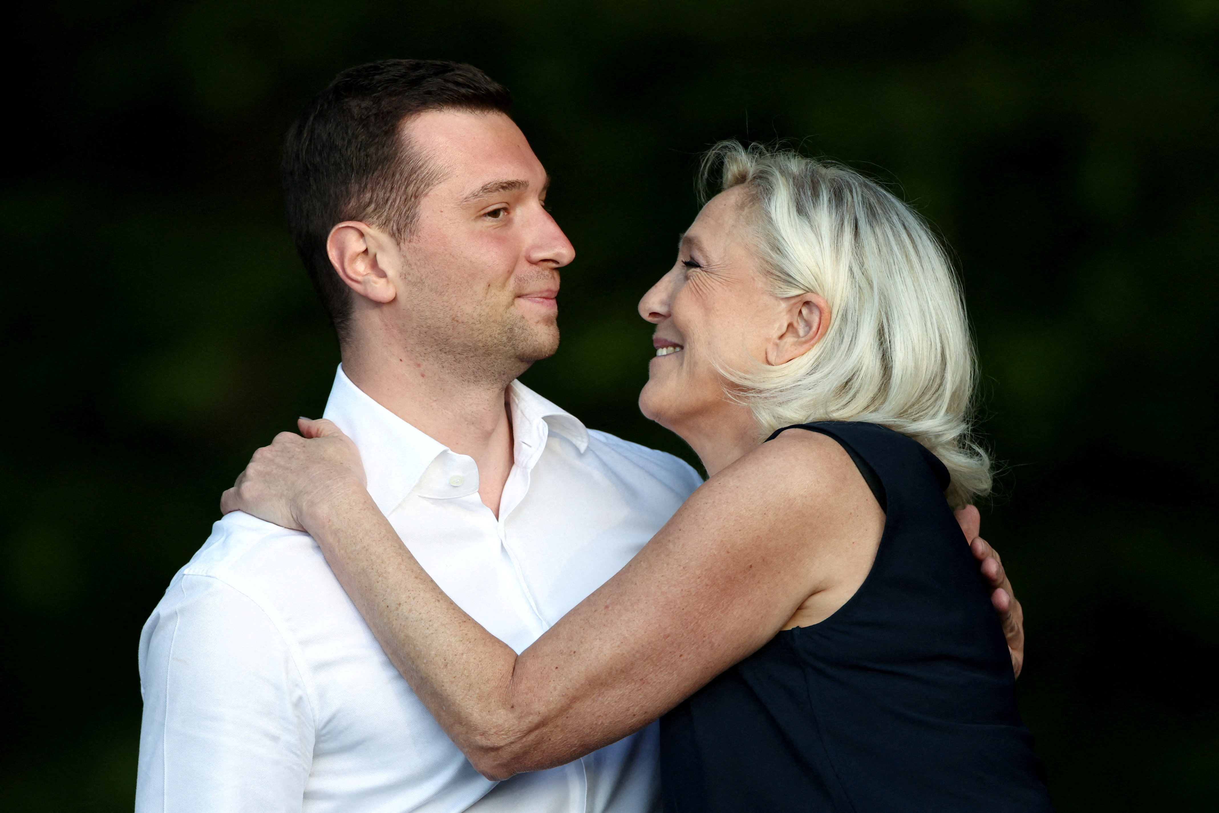 French far-right leader Marine Le Pen and Jordan Bardella, president of the French far-right Rassemblement National (National Rally - RN) political party, embrace after speaking at a country fair with supporters in Lievin, northern France, July 4, 2026. REUTERS/Tom Nicholson TPX IMAGES OF THE DAY