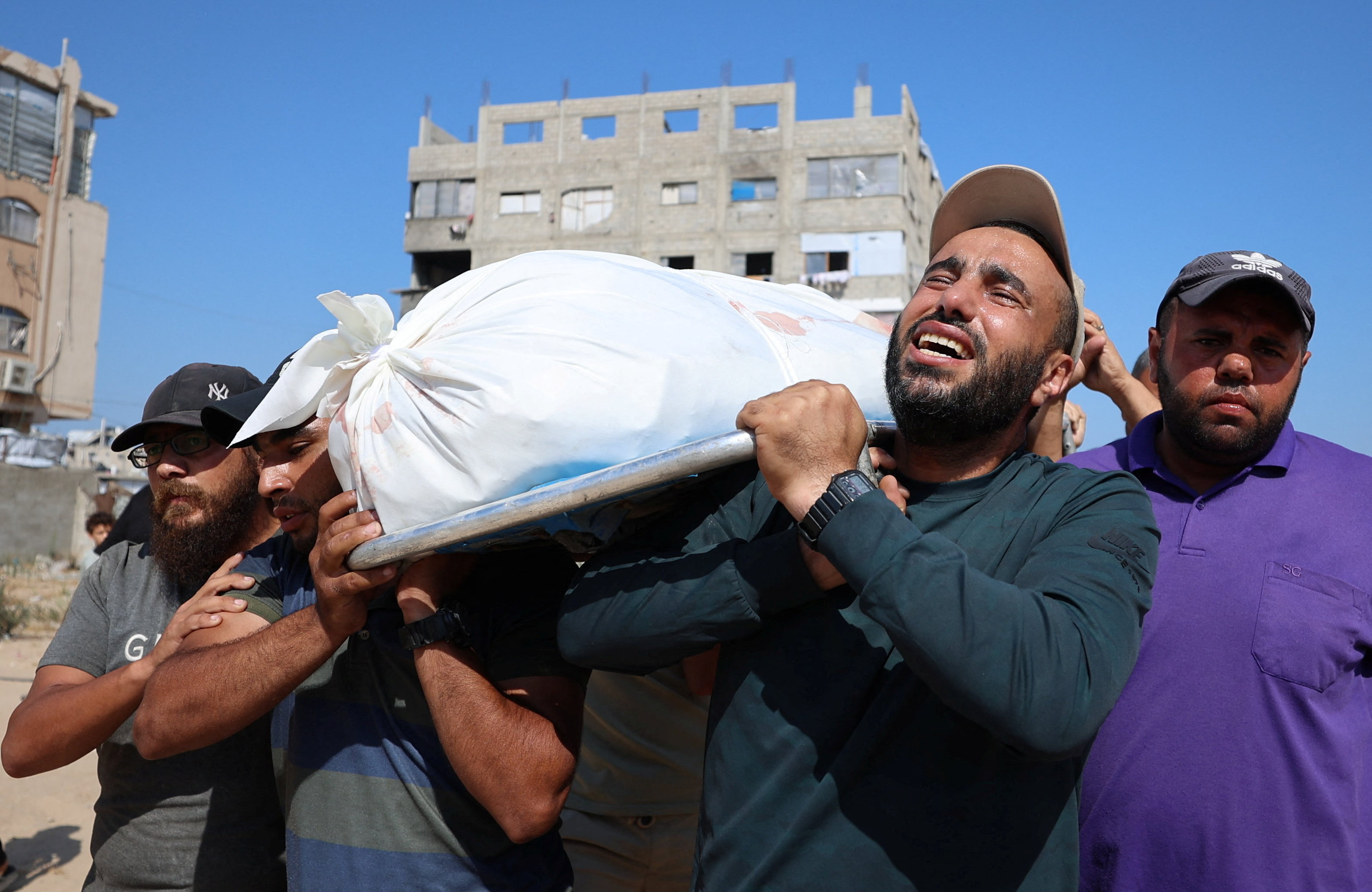 Mourners carry the body of a Palestinian killed in an Israeli attack on an apartment in Gaza City