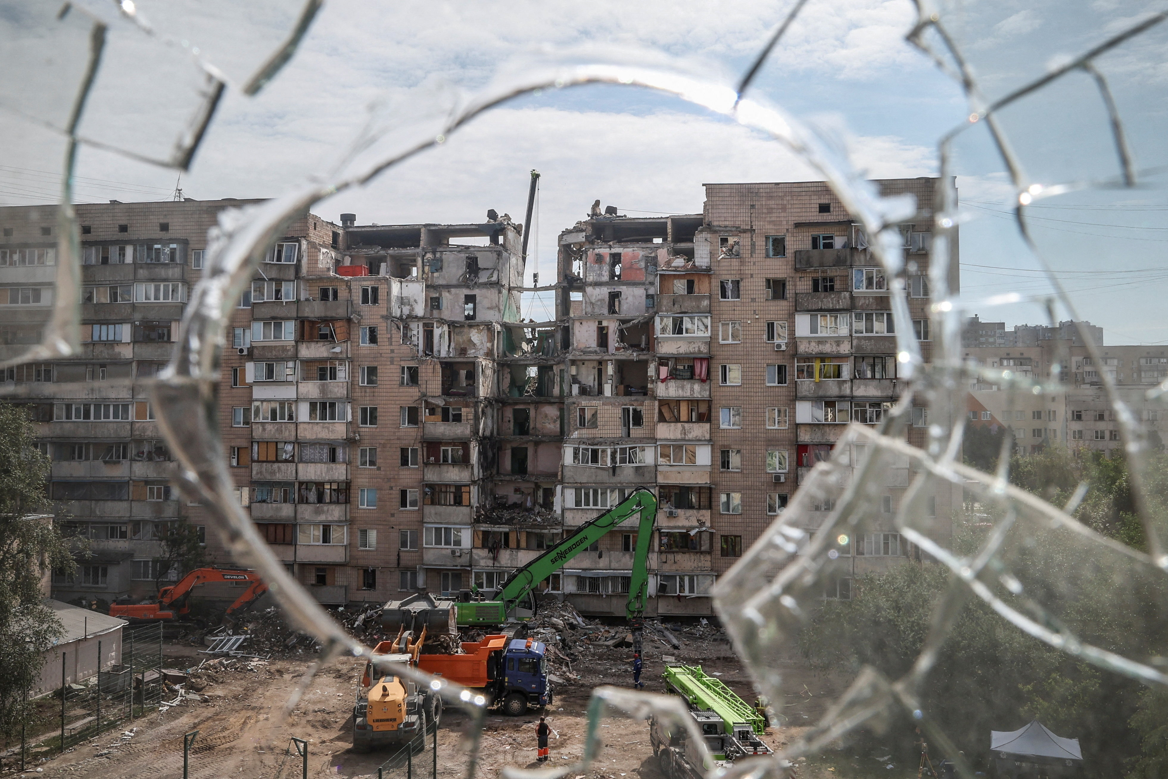 Rescuers working at a site of a Russian missile and drone strike on the previous day, during which residential building was heavily damaged, amid Russia's attack on Ukraine, are seen through broken glass, in Kyiv, Ukraine, July 7, 2026. REUTERS/Alina Smutko TPX IMAGES OF THE DAY