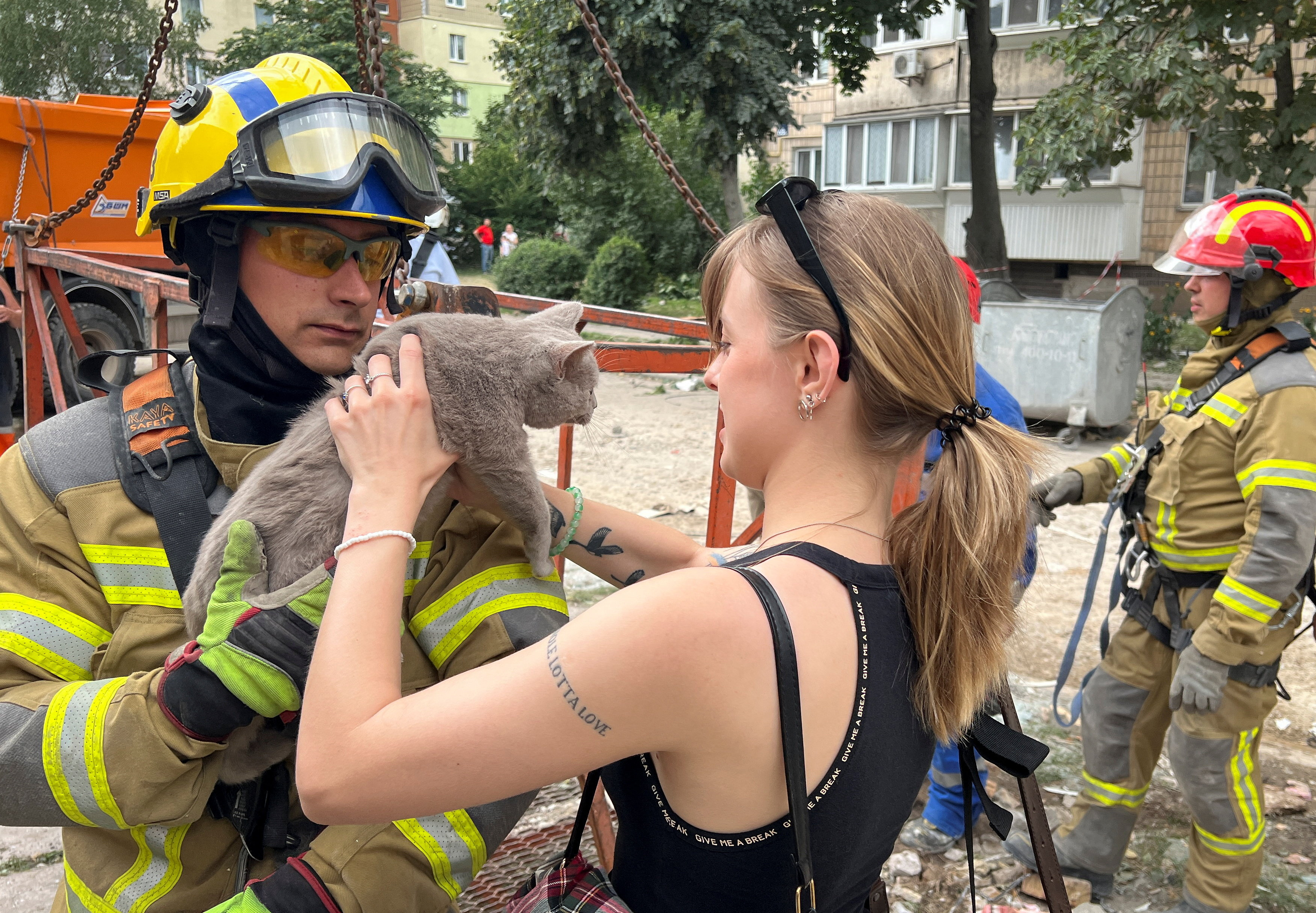 A rescuer hands a cat named Boniya, found under the rubble of an apartment building damaged by a Russian missile strike a day earlier, to Anastasia Sorokina, a friend of the cat owner who had lost her husband's brother and his wife living in the apartment next door as a result of the attack, amid Russia's attack on Ukraine, in Kyiv, Ukraine July 7, 2026. REUTERS/Sergiy Karazy TPX IMAGES OF THE DAY