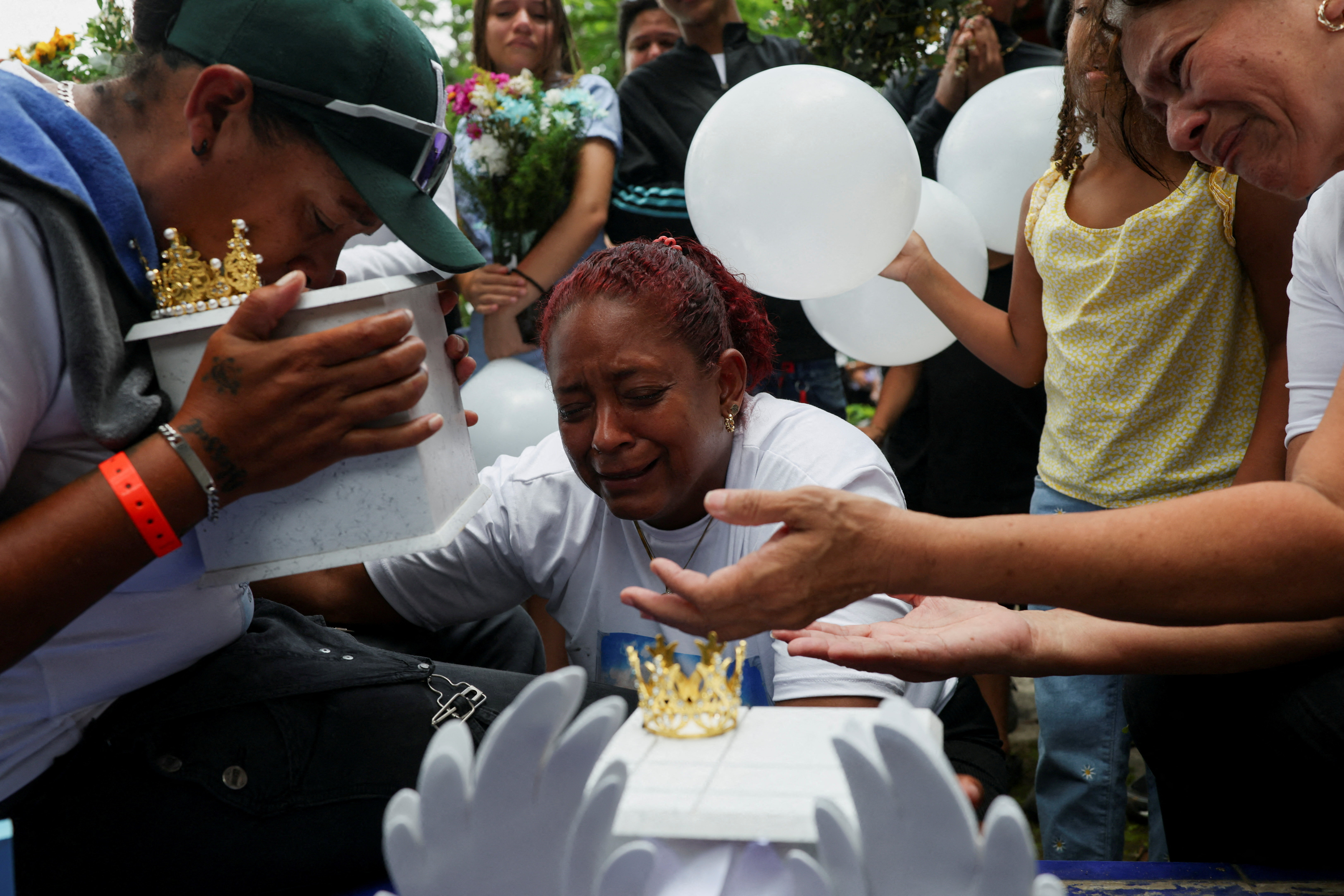 Zuleiry Martinez, sister of Ashley Martinez, 29, and aunt of Kalani Martinez, 2, who were killed in the June 24 earthquakes, kisses her sister's ashes before burying them, as her other sister, Caidelys, reacts beside her at Tarmas cemetery, in La Guaira, Venezuela, July 15, 2026. REUTERS/Pablo Sanhueza TPX IMAGES OF THE DAY