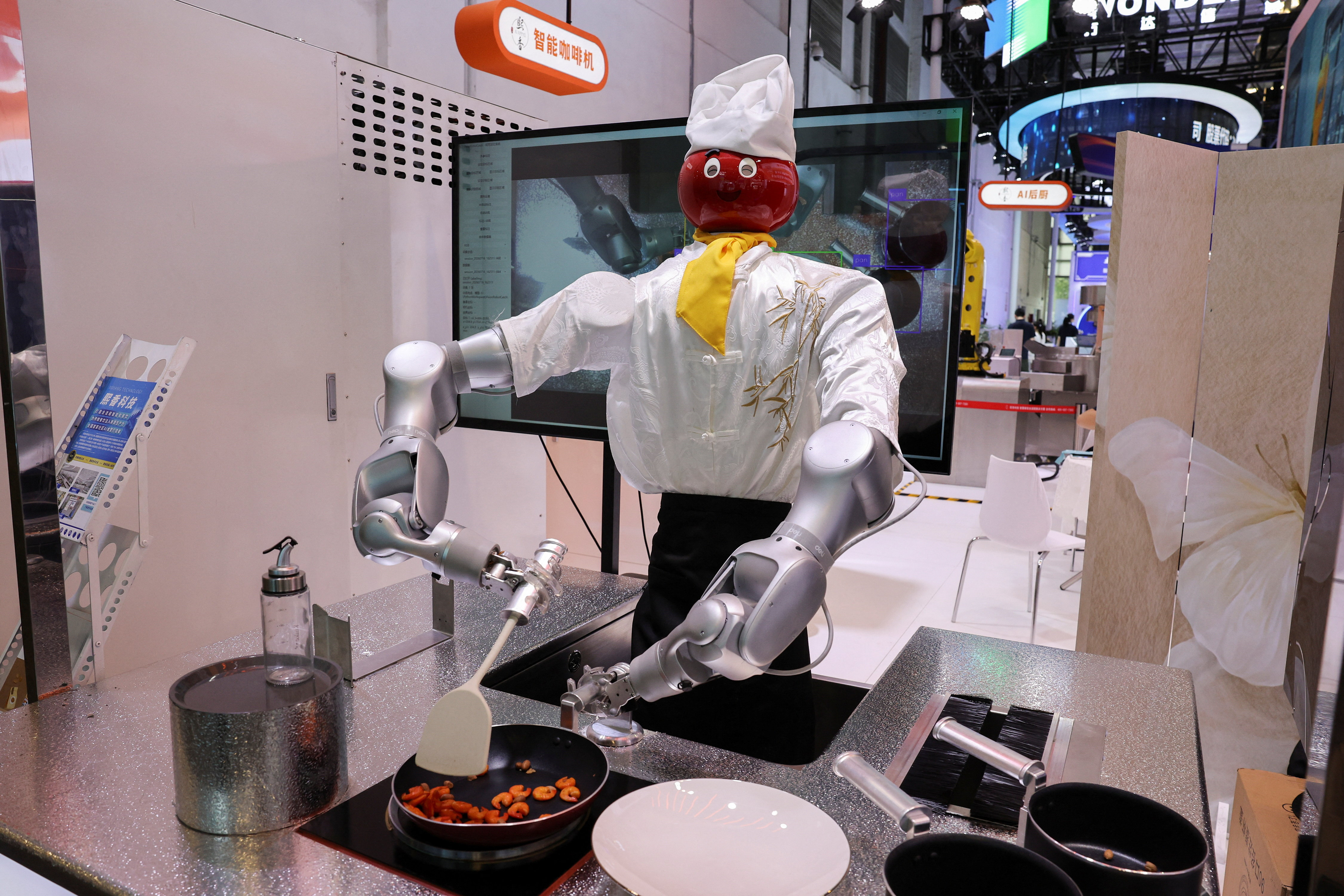 A humanoid robot that cooks is displayed at the Xi Xiang booth during the World Artificial Intelligence Conference (WAIC) in Shanghai, China, July 17, 2026