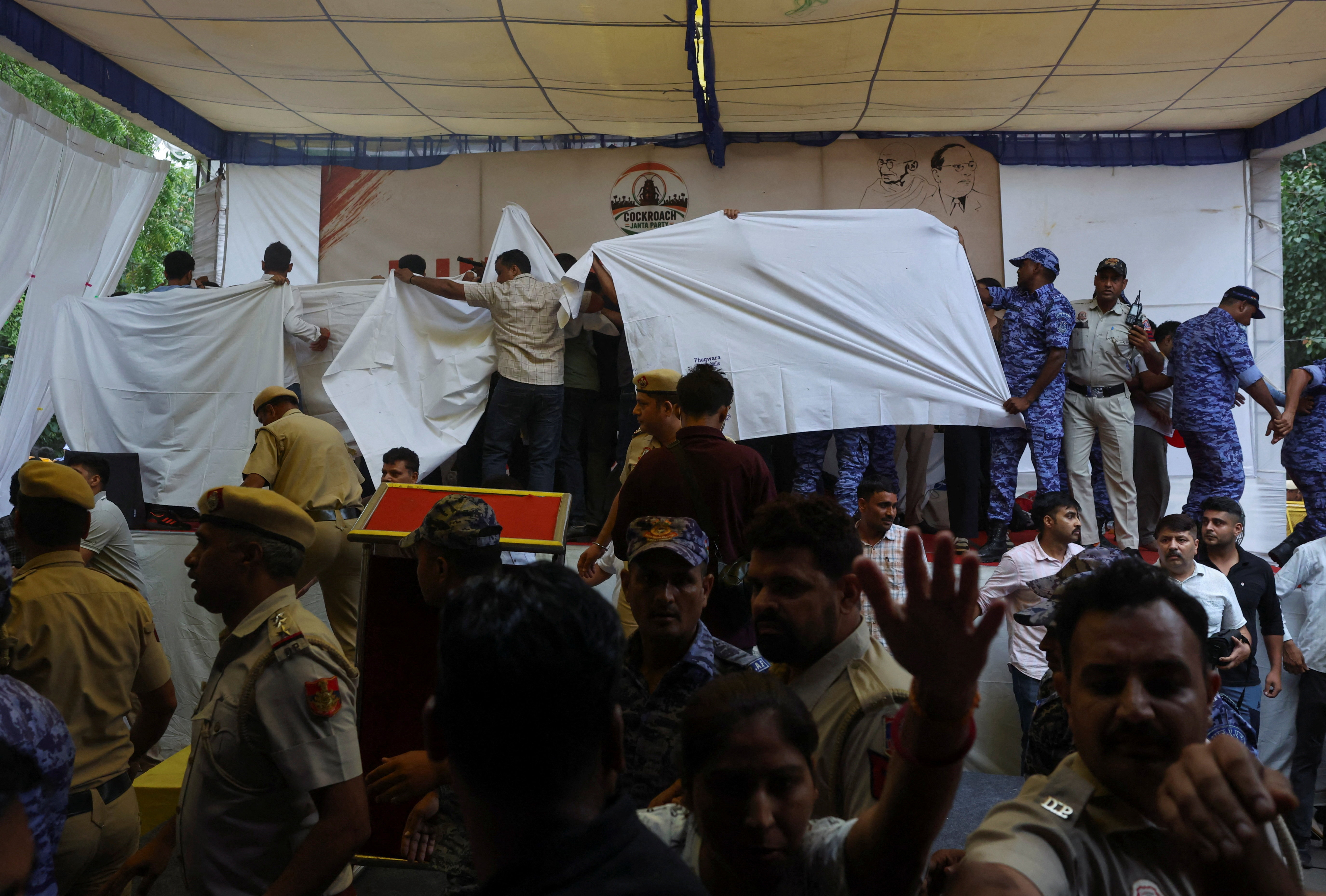Authorities cover the stage as they prepare to take Sonam Wangchuk to hospital to break his hunger strike at Jantar Mantar, New Delhi, India, on July 18, 2026